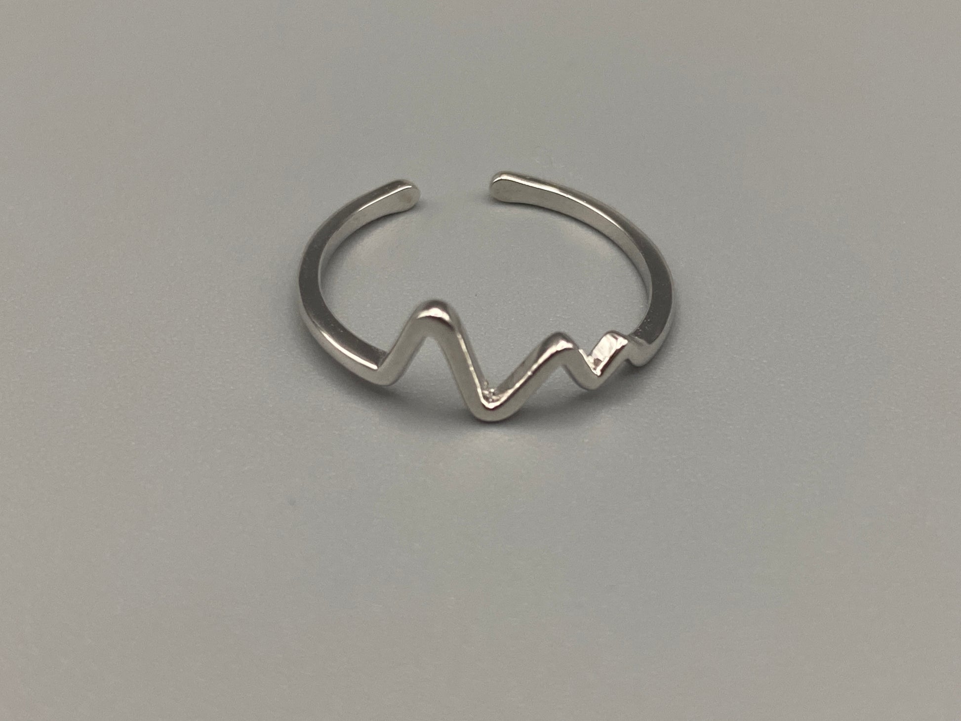 Pulse Ring Silver: This adjustable ring features a heartbeat pattern, crafted from high-quality 925 sterling silver and plated with a non-tarnish, waterproof finish. It is designed to be anti-allergy, making it perfect for any occasion, whether it’s an anniversary, engagement, wedding, or party.