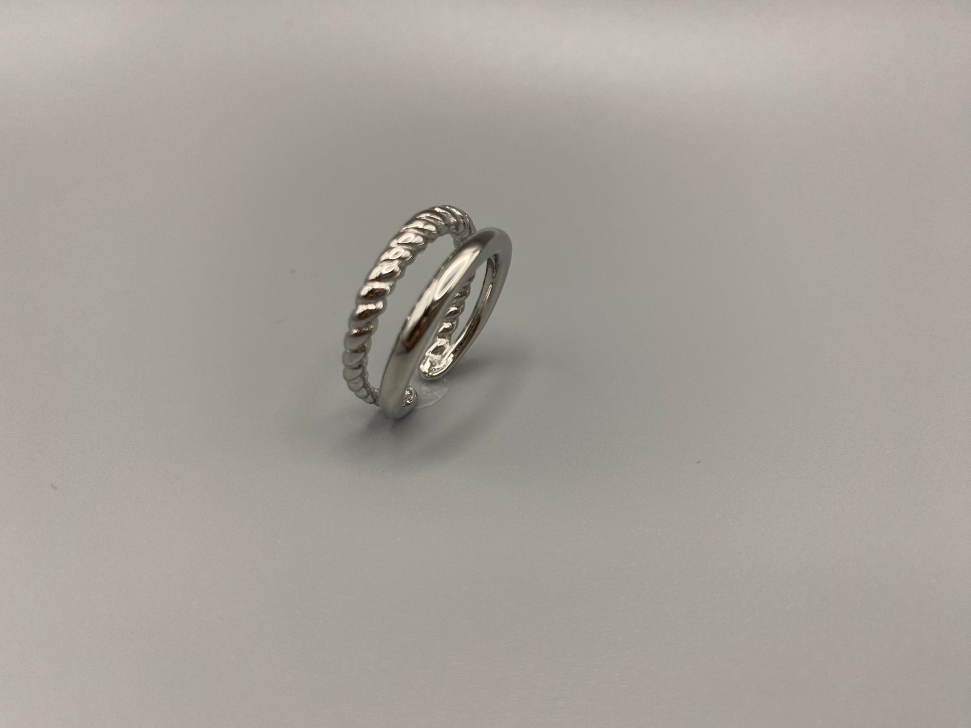 Selene Twin Band Ring Silver: This ring features a unique combination of a textured rope band and a smooth plain band, both gold plated for a luxurious finish. The titanium PVD ensures durability and resistance to wear, while the stainless steel construction adds strength and longevity. The unique twin band design combines elegance and modernity. Available in ring size 7, it is perfect for those who wear this size. Make a statement with this versatile and chic accessory that complements any look.