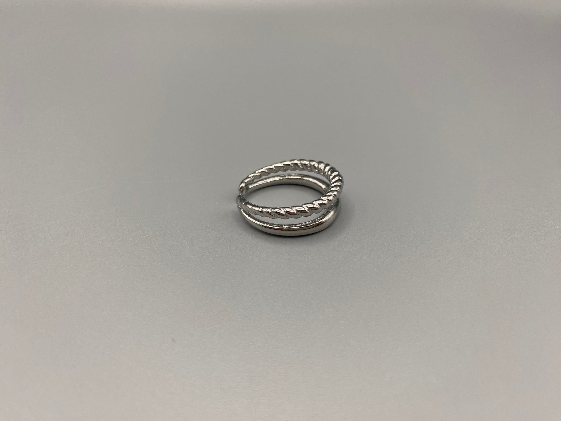 Selene Twin Band Ring Silver: This ring features a unique combination of a textured rope band and a smooth plain band, both gold plated for a luxurious finish. The titanium PVD ensures durability and resistance to wear, while the stainless steel construction adds strength and longevity. The unique twin band design combines elegance and modernity. Available in ring size 7, it is perfect for those who wear this size. Make a statement with this versatile and chic accessory that complements any look.