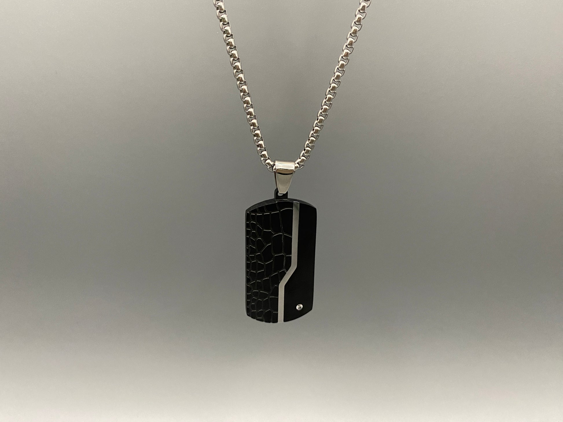  “Sentinel Black Pendant Stainless Steel Men’s Dog Necklace featuring a sleek black finish and a cross pattern, displayed on a strand chain.”