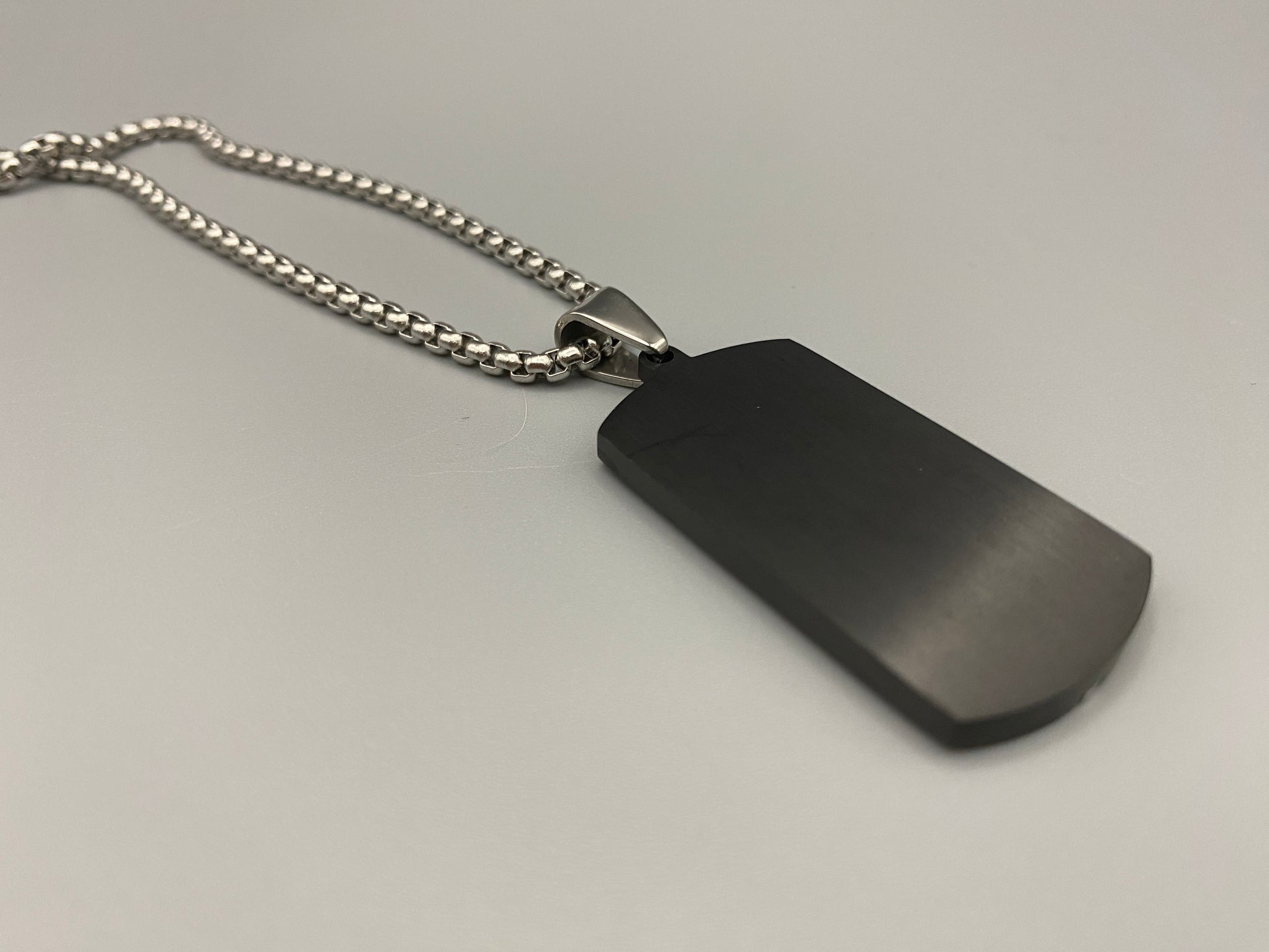  “Sentinel Black Pendant Stainless Steel Men’s Dog Necklace featuring a sleek black finish and a cross pattern, displayed on a strand chain.”