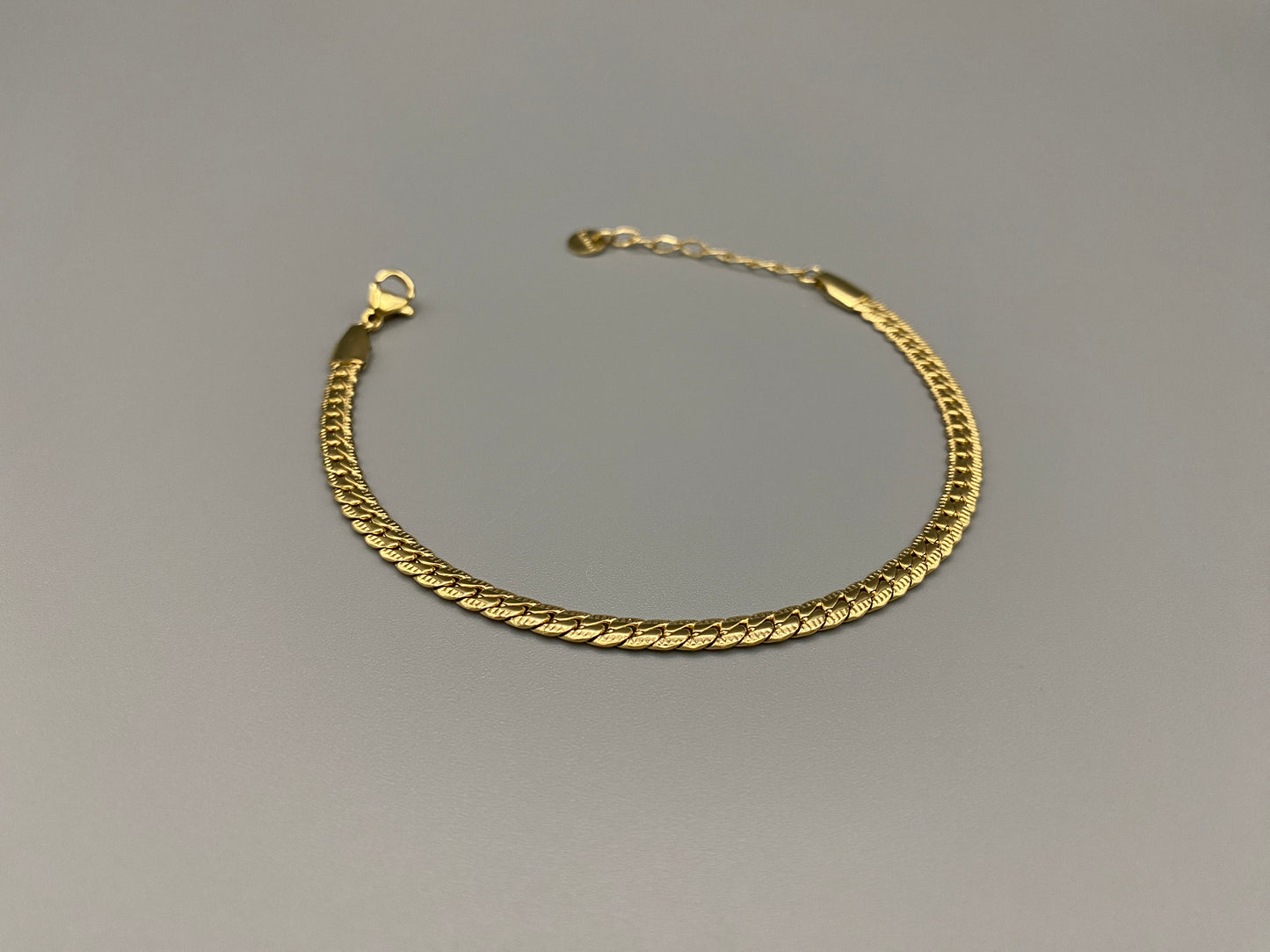 “Seraphina Bracelet in gold with a unique snake-linked design, featuring luxurious gold plating. Adjustable length of 17 cm with a 3 cm extension. Durable construction ensures long-lasting wear and tarnish resistance.”