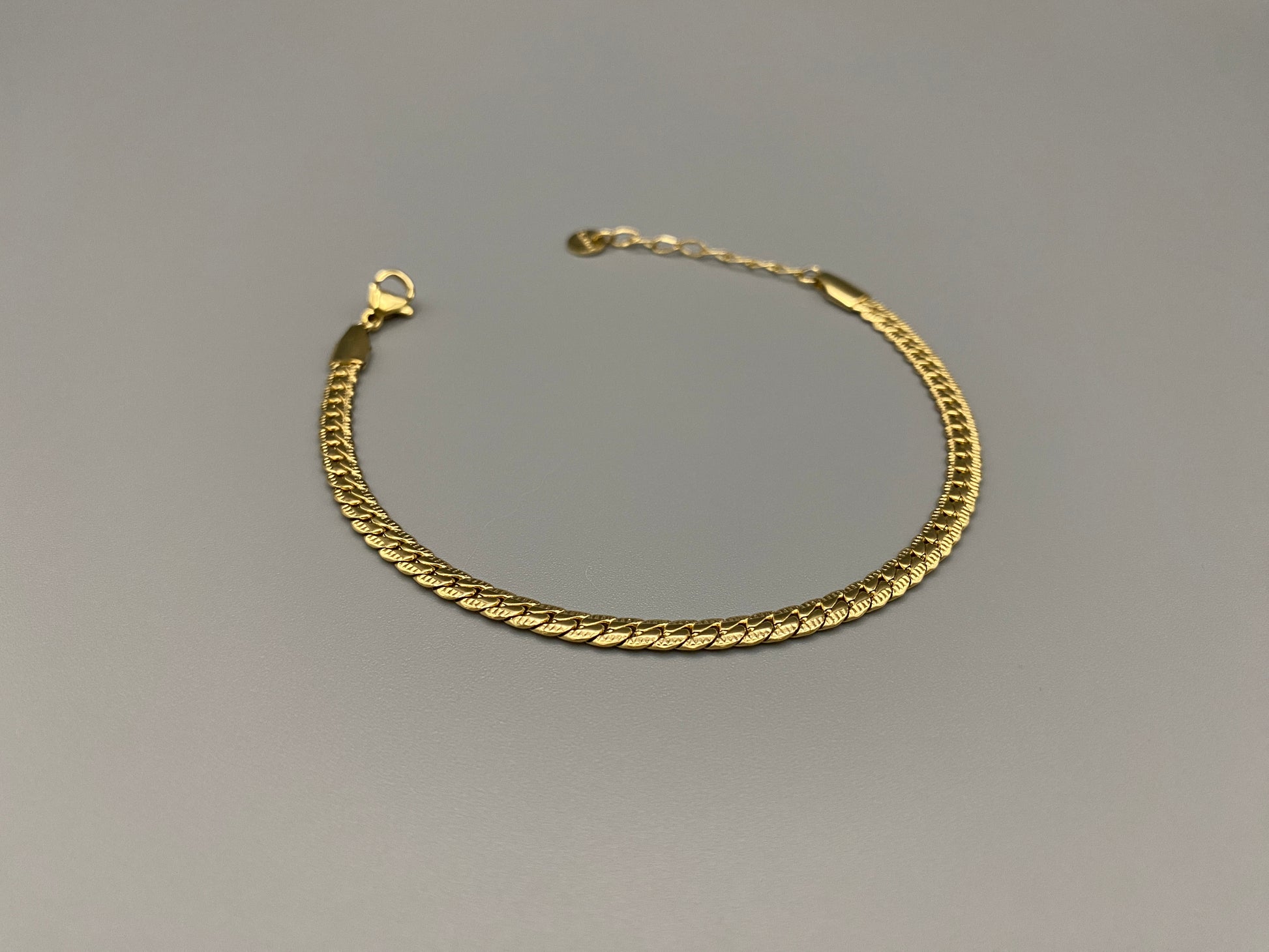 “Seraphina Bracelet in gold with a unique snake-linked design, featuring luxurious gold plating. Adjustable length of 17 cm with a 3 cm extension. Durable construction ensures long-lasting wear and tarnish resistance.”