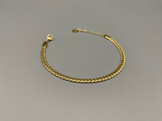 “Seraphina Bracelet in gold with a unique snake-linked design, featuring luxurious gold plating. Adjustable length of 17 cm with a 3 cm extension. Durable construction ensures long-lasting wear and tarnish resistance.”
