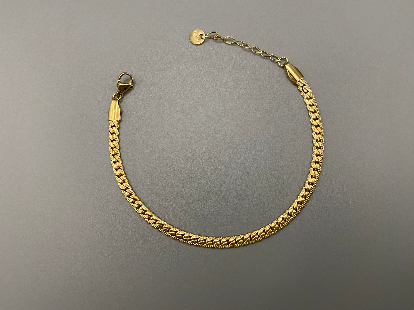 “Seraphina Bracelet in gold with a unique snake-linked design, featuring luxurious gold plating. Adjustable length of 17 cm with a 3 cm extension. Durable construction ensures long-lasting wear and tarnish resistance.”