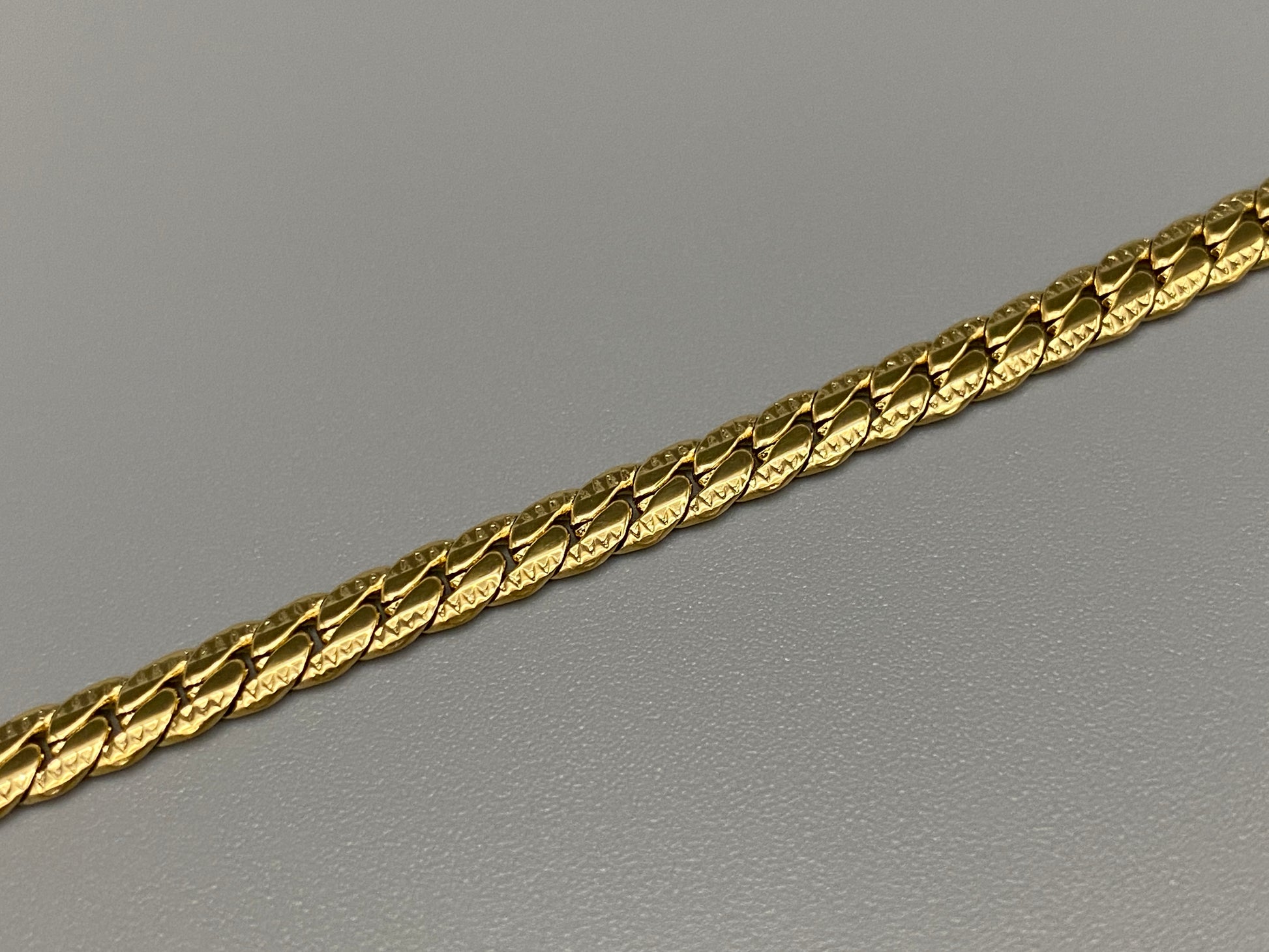 “Seraphina Bracelet in gold with a unique snake-linked design, featuring luxurious gold plating. Adjustable length of 17 cm with a 3 cm extension. Durable construction ensures long-lasting wear and tarnish resistance.”