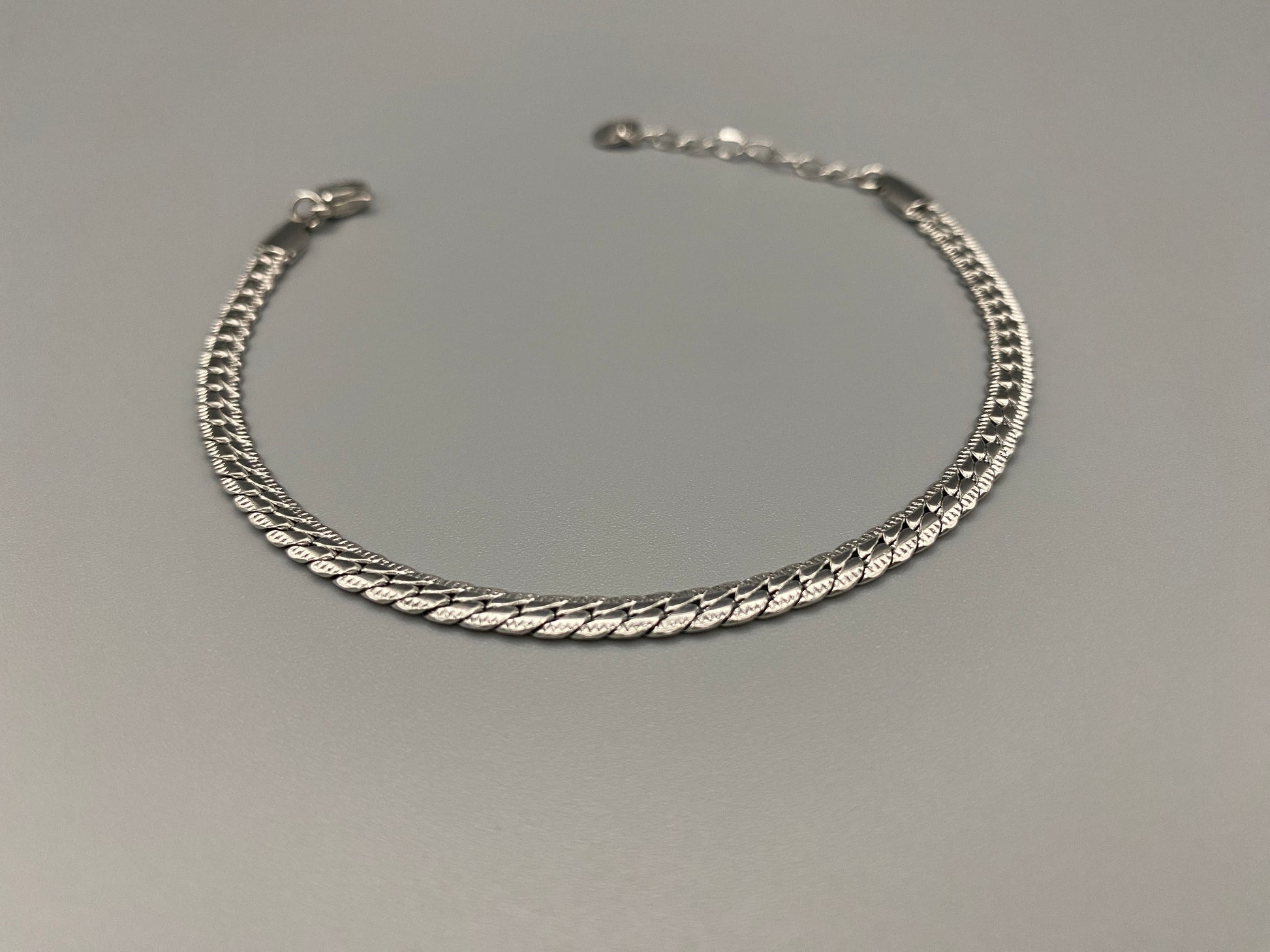 “Seraphina Bracelet in Silver with a unique snake-linked design, featuring luxurious Silver plating. Adjustable length of 17 cm with a 3 cm extension. Durable construction ensures long-lasting wear and tarnish resistance.”