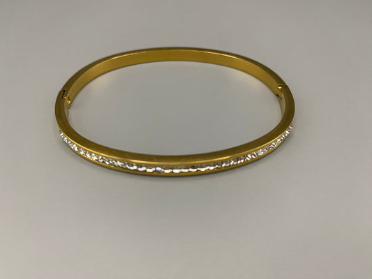 “Simone Encrusted Bangle in gold with 18K gold plating and gemstone inlay, offering a radiant and luxurious finish. Durable construction ensures long-lasting wear and tarnish resistance. Perfect for both everyday wear and special occasions.”