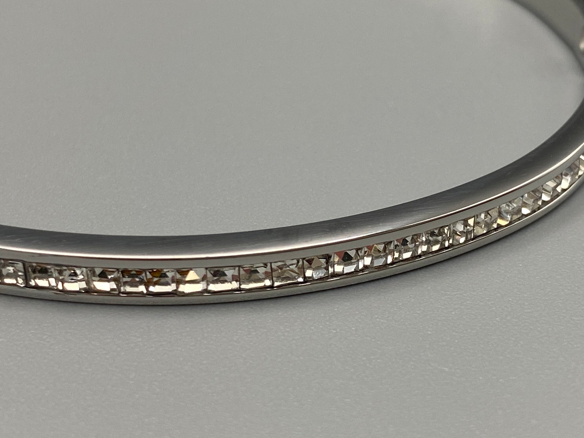 Simone Encrusted Bangle in silver with silver plating and gemstone inlay, offering a radiant and luxurious finish. Durable construction ensures long-lasting wear and tarnish resistance. Perfect for both everyday wear and special occasions.”