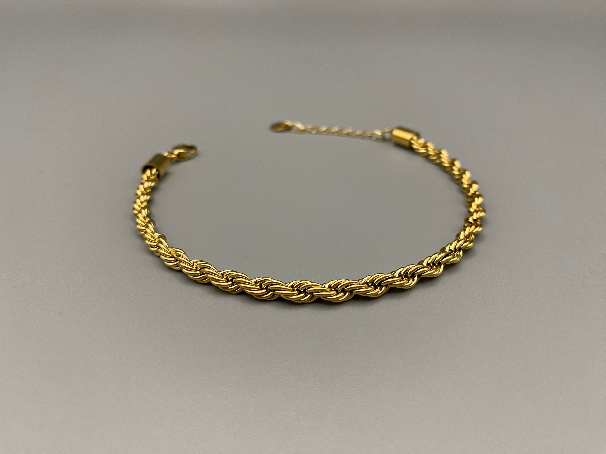 “Spiral Splendor Bracelet in gold with an intricate spiral design, featuring luxurious gold plating and PVD plating for durability. Made from stainless steel, adjustable length of 17.5 cm with a 3 cm extension.”