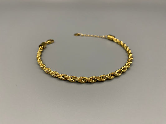 “Spiral Splendor Bracelet in gold with an intricate spiral design, featuring luxurious gold plating and PVD plating for durability. Made from stainless steel, adjustable length of 17.5 cm with a 3 cm extension.”