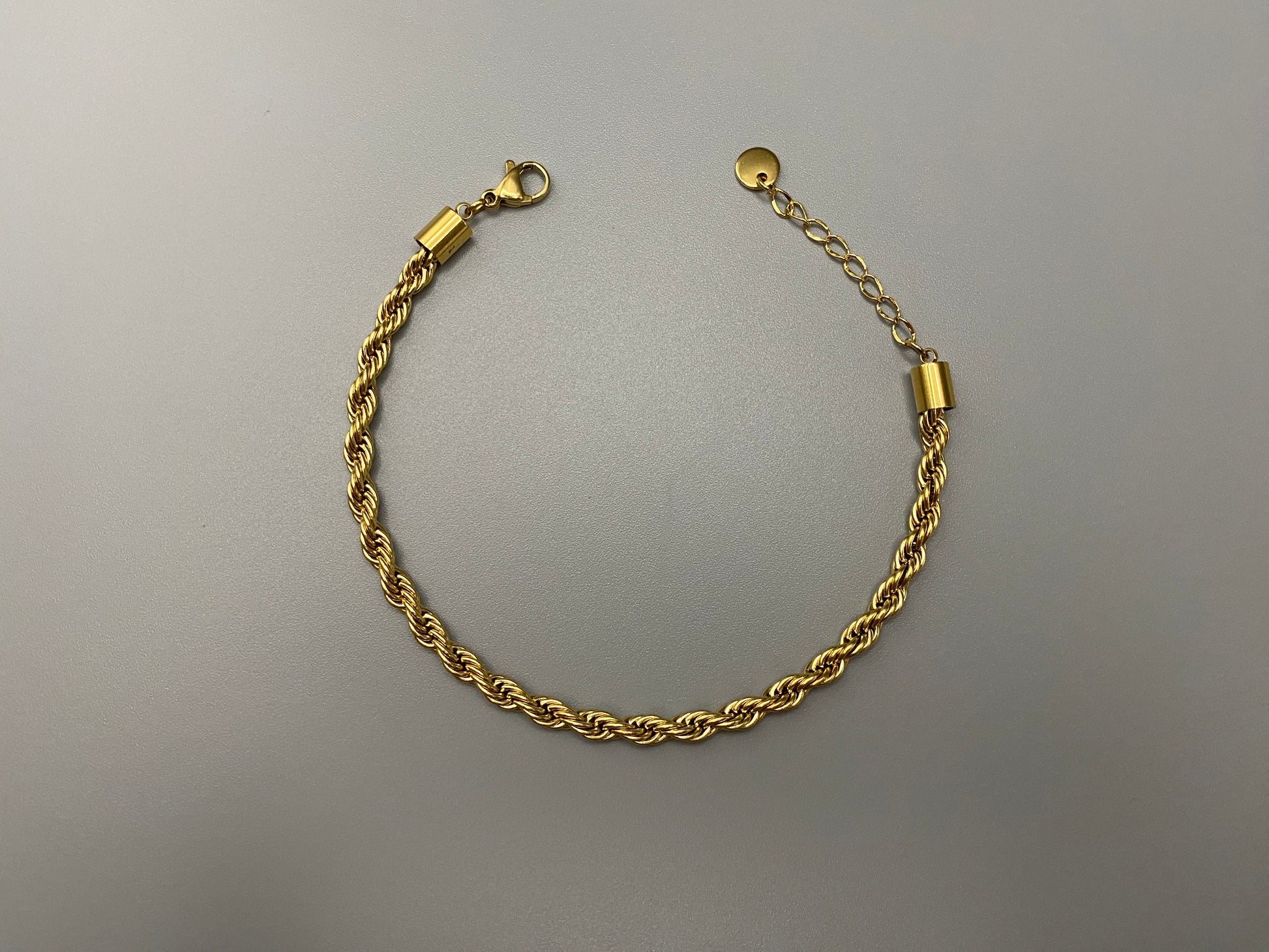 “Spiral Splendor Bracelet in gold with an intricate spiral design, featuring luxurious gold plating and PVD plating for durability. Made from stainless steel, adjustable length of 17.5 cm with a 3 cm extension.”