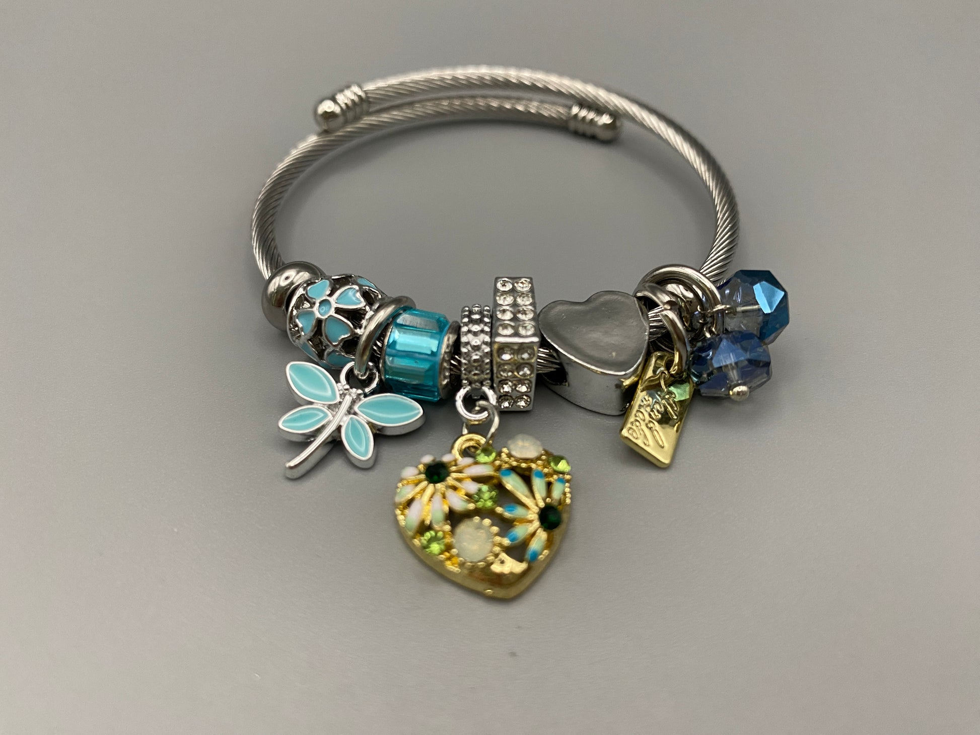 “Stellar Charm Bracelet in blue with playful charms including a heart, butterfly, and cube, crafted from high-quality stainless steel. Suitable for both women and kids, making it a perfect gift for any occasion.”