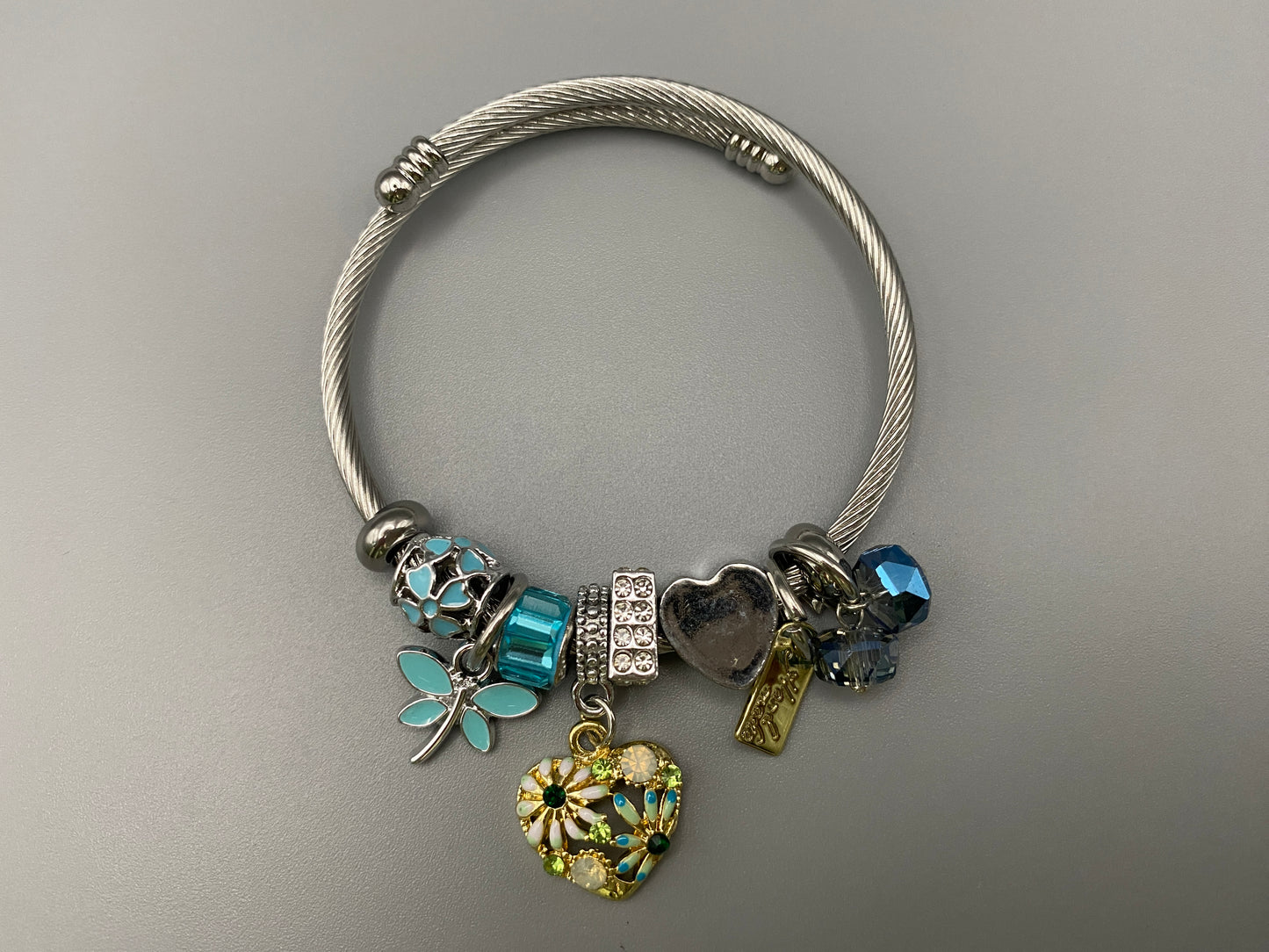 “Stellar Charm Bracelet in blue with playful charms including a heart, butterfly, and cube, crafted from high-quality stainless steel. Suitable for both women and kids, making it a perfect gift for any occasion.”