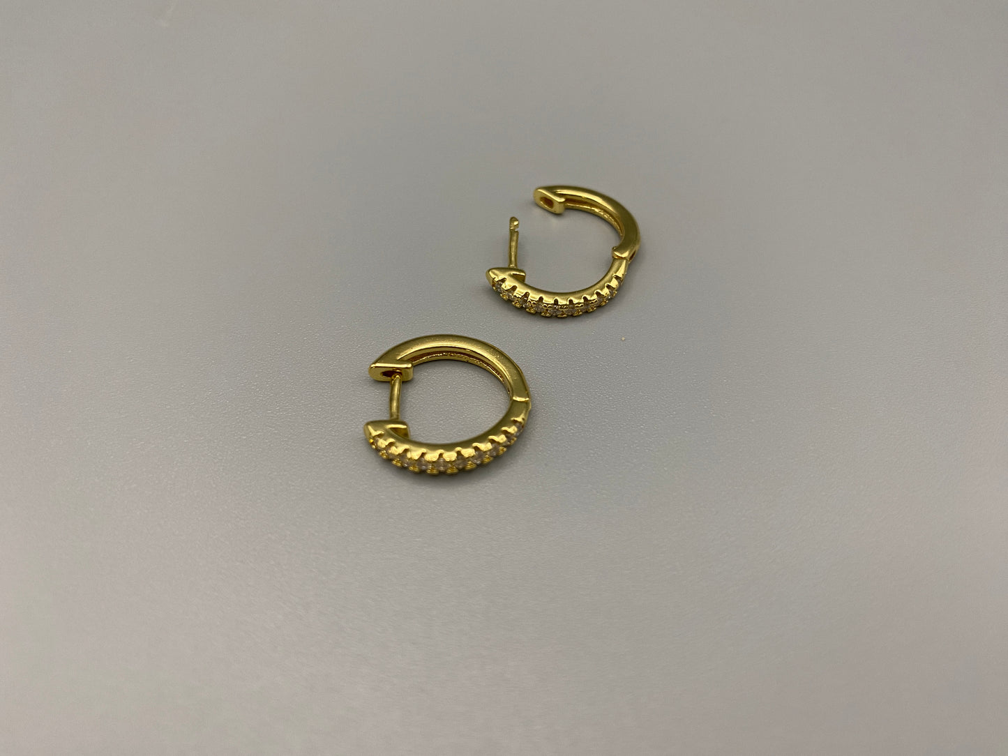 “Taga Elegant Hoop Earrings Gold: A perfect blend of sophistication and modern design, featuring gold plating for a luxurious finish, durable stainless steel construction, and sparkling zirconia gems. Stylish and contemporary, perfect for any occasion.”