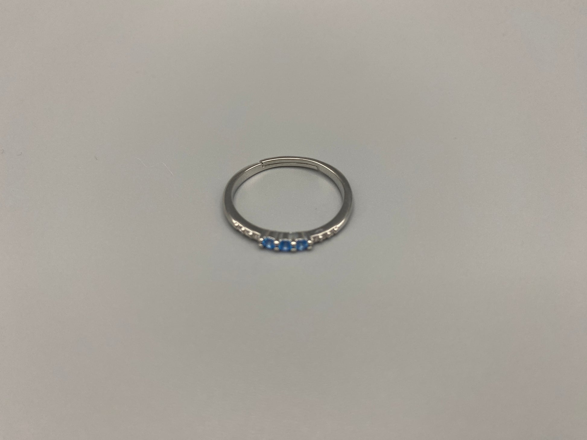 Tanvi Blue Ring: This stunning piece features alternating brilliant blue and clear cubic zirconia stones, set in a sleek silver-plated band. The adjustable fit ensures comfort for any finger size. The ring is non-tarnish and waterproof, maintaining its shine over time. Perfect for everyday wear, the Tanvi ring is your go-to accessory for timeless beauty.