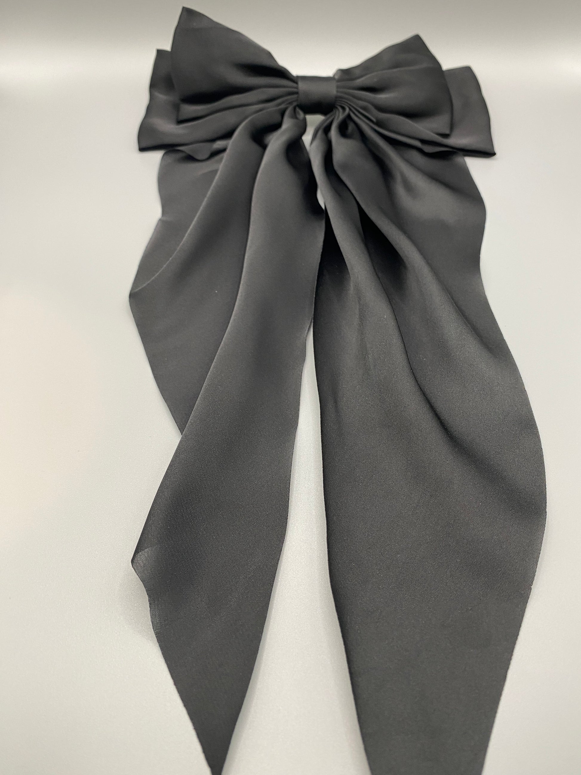 “The Amy Oversized Hair Bow in Black, crafted from high-quality satin with an oversized bowknot design. Features a minimalist spring clamp for a secure fit. Perfect for stylish updos, daily wear, and special occasions.”