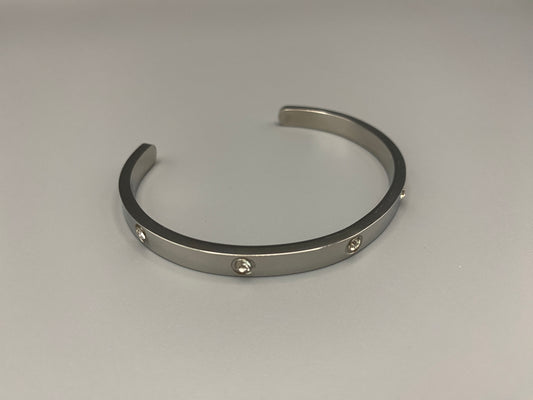 “Lucy Bangle in silver with silver plating and gemstone inlay, offering a radiant and luxurious finish. Durable construction ensures long-lasting wear and tarnish resistance. Perfect for both everyday wear and special occasions.”