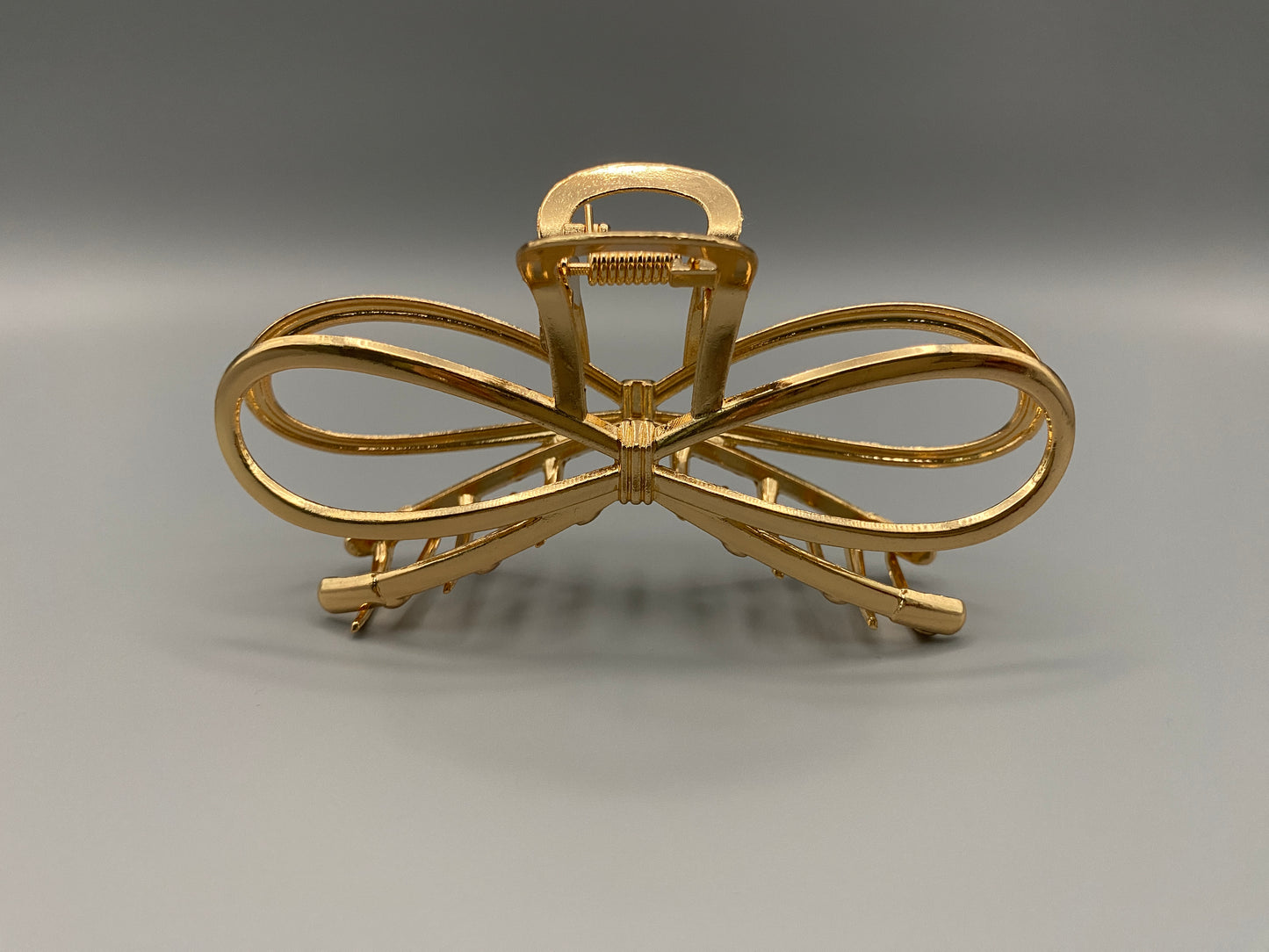 “The Luxe Claw Clip Metal Bow in Gold, crafted from high-quality, durable metal. Measures 11 cm, featuring a luxurious gold finish and unique link design. Perfect for securing various hair types and styles, suitable for both everyday wear and special occasions.”