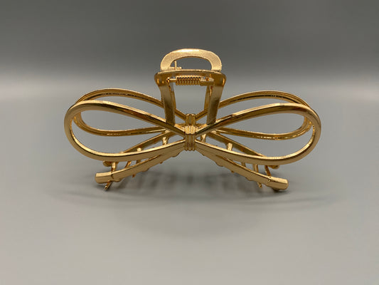 “The Luxe Claw Clip Metal Bow in Gold, crafted from high-quality, durable metal. Measures 11 cm, featuring a luxurious gold finish and unique link design. Perfect for securing various hair types and styles, suitable for both everyday wear and special occasions.”
