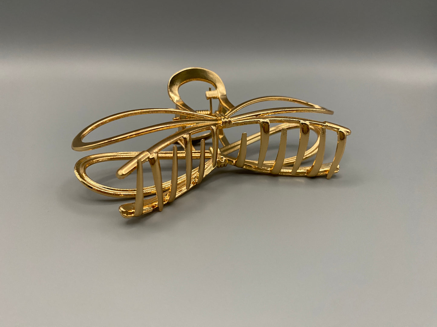 The Luxe Claw Clip Metal Bow in Gold, crafted from high-quality, durable m“etal. Measures 11 cm, featuring a luxurious gold finish and unique link design. Perfect for securing various hair types and styles, suitable for both everyday wear and special occasions.”