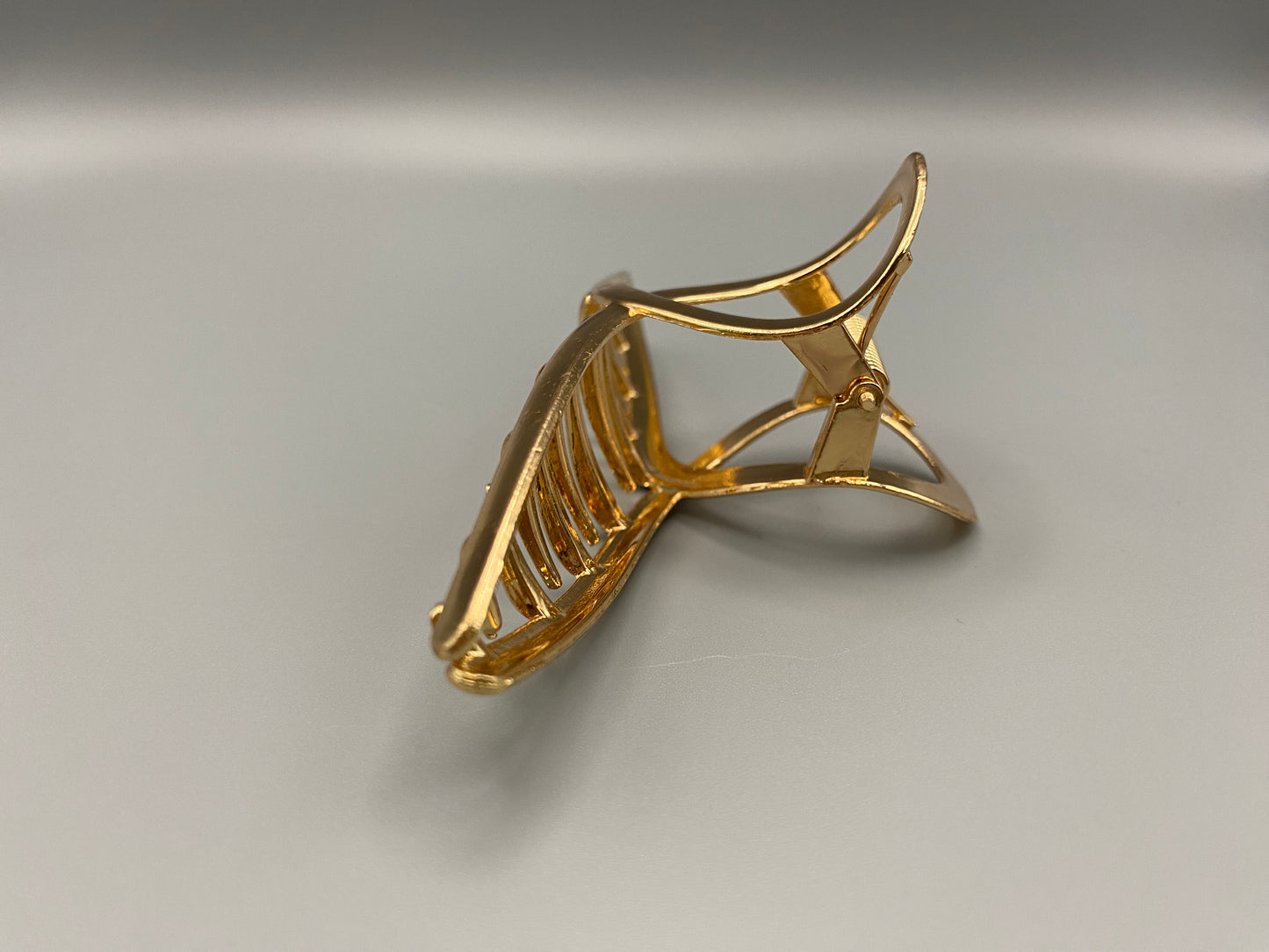 The Luxe Claw Clip Metal Bow in Gold, crafted from high-quality, durable metal. Measures 11 cm, featuring a luxurious gold finish and unique link design. Perfect for securing various 