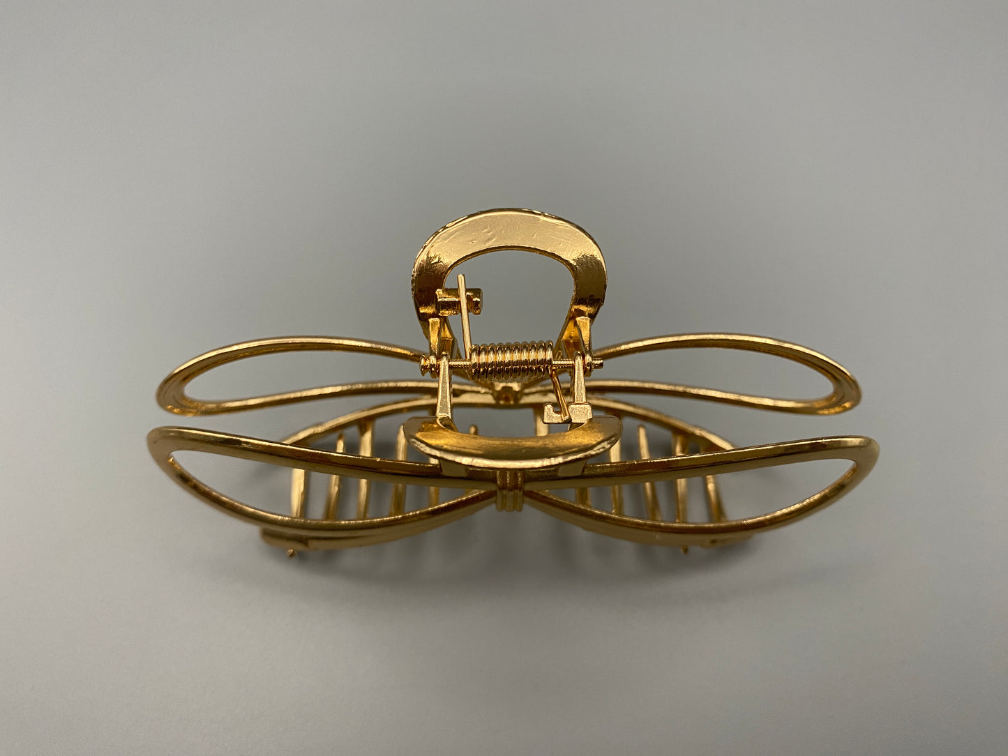 The Luxe Claw Clip Metal Bow in Gold, crafted from high-quality, durable m“etal. Measures 11 cm, featuring a luxurious gold finish and unique link design. Perfect for securing various hair types and styles, suitable for both everyday wear and special occasions.”