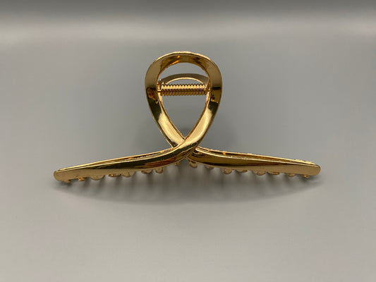 The Luxe Claw Clip Metal Bow in Gold, crafted from high-quality, durable metal. Measures 11 cm, featuring a luxurious gold finish and unique link design. Perfect for securing various hair types and styles, suitable for both everyday wear and special occasions.”