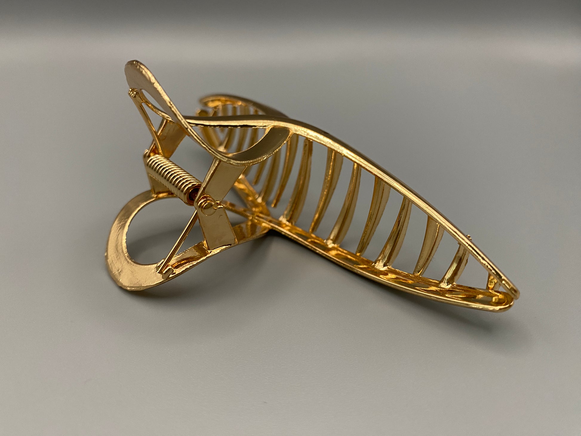 The Luxe Claw Clip Metal Bow in Gold, crafted from high-quality, durable metal. Measures 11 cm, featuring a luxurious gold finish and unique link design. Perfect for securing various hair types and styles, suitable for both everyday wear and special occasions.”