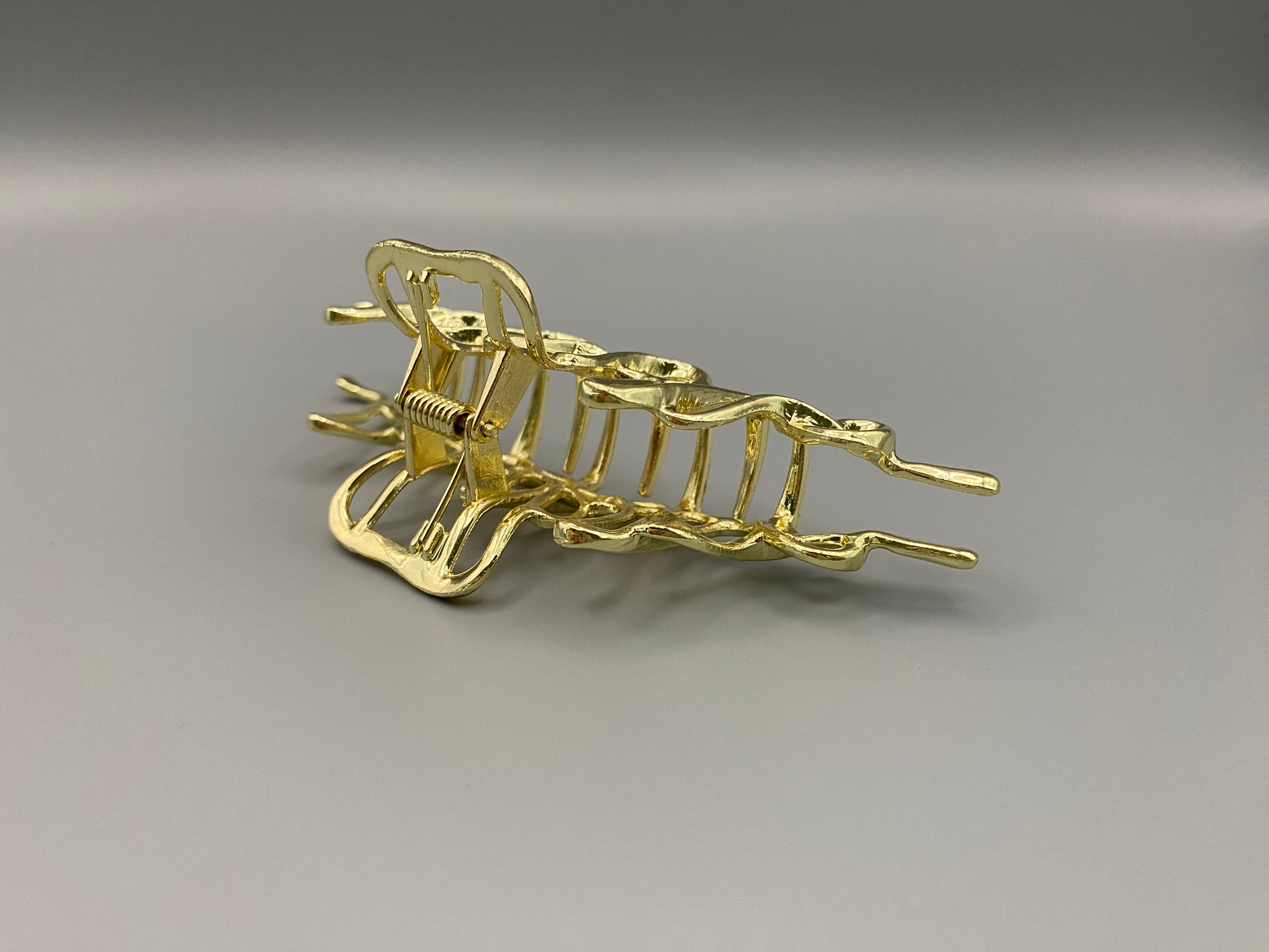 “The Luxe Claw Clip Metal Lightning in Gold, crafted from high-quality, durable metal. Measures 11 cm, featuring a luxurious gold finish and unique link design. Perfect for securing various hair types and styles, suitable for both everyday wear and special occasions.”