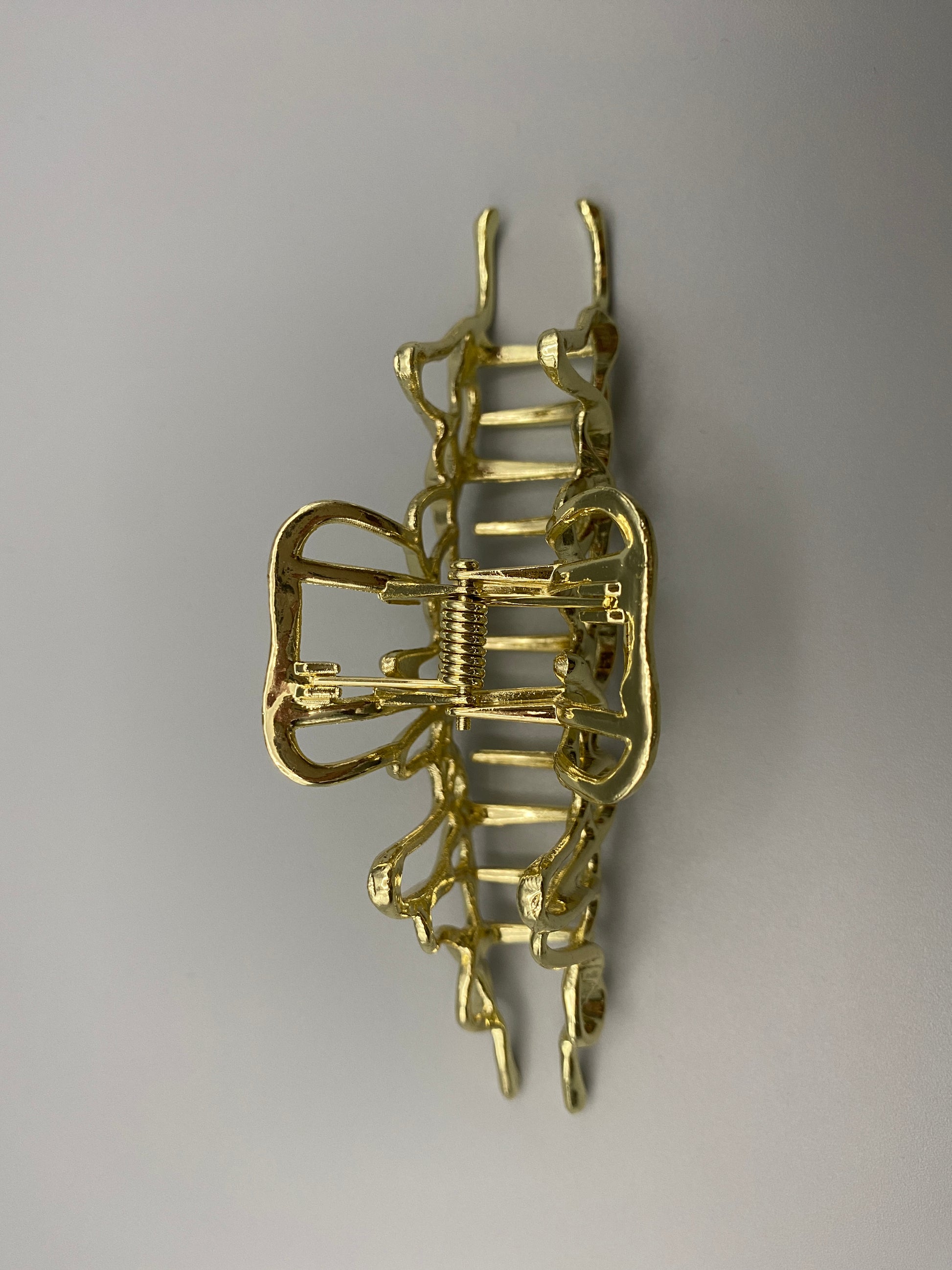 “The Luxe Claw Clip Metal Lightning in Gold, crafted from high-quality, durable metal. Measures 11 cm, featuring a luxurious gold finish and unique link design. Perfect for securing various hair types and styles, suitable for both everyday wear and special occasions.”