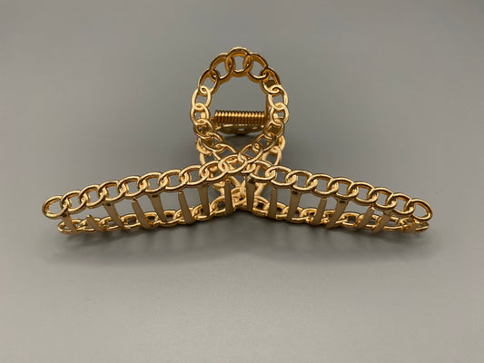 “The Luxe Claw Clip Metal Link in Gold, crafted from high-quality, durable metal. Measures 11 cm, featuring a luxurious gold finish and unique link design. Perfect for securing various hair types and styles, suitable for both everyday wear and special occasions.”