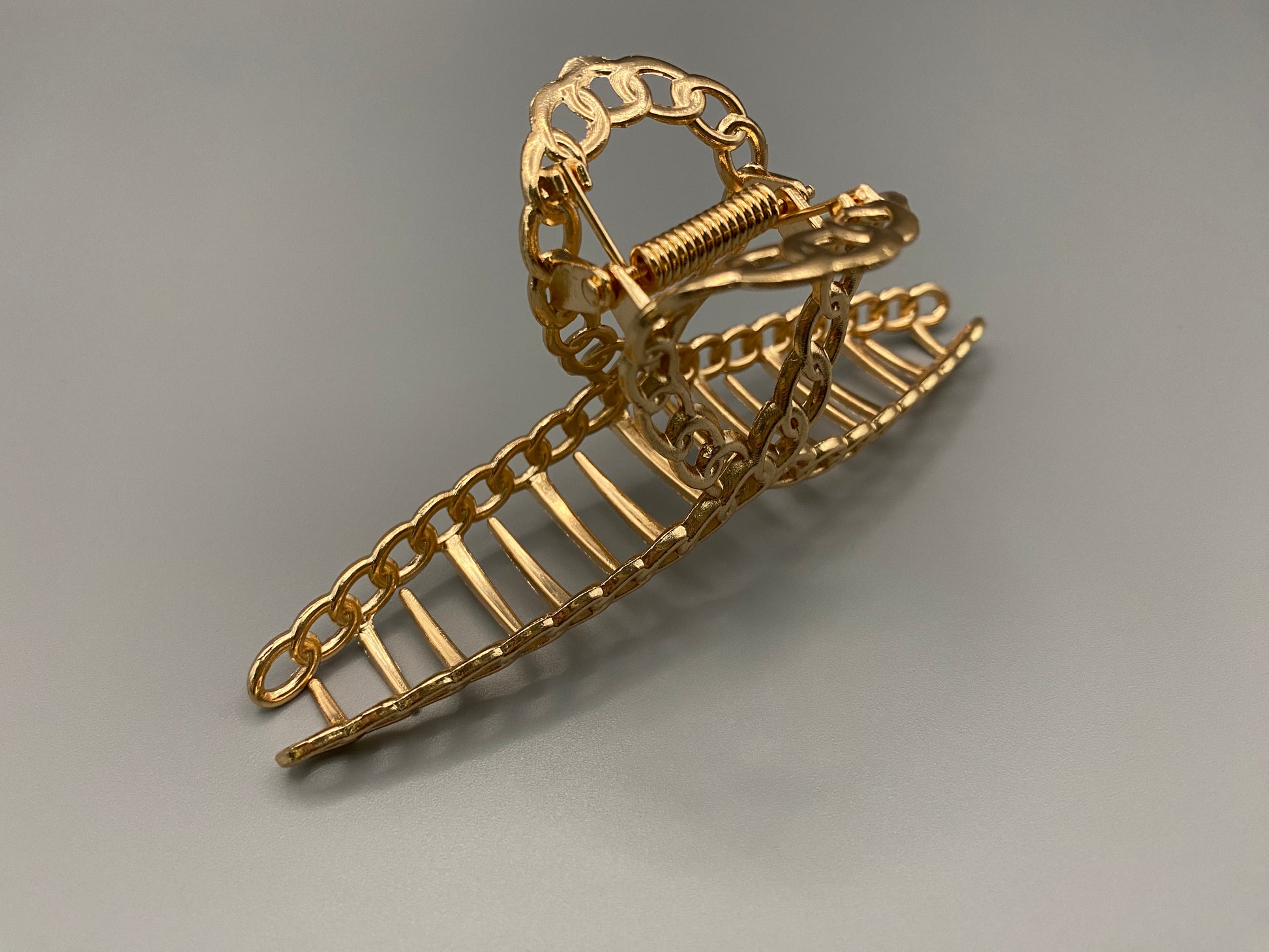 “The Luxe Claw Clip Metal Link in Gold, crafted from high-quality, durable metal. Measures 11 cm, featuring a luxurious gold finish and unique link design. Perfect for securing various hair types and styles, suitable for both everyday wear and special occasions.”