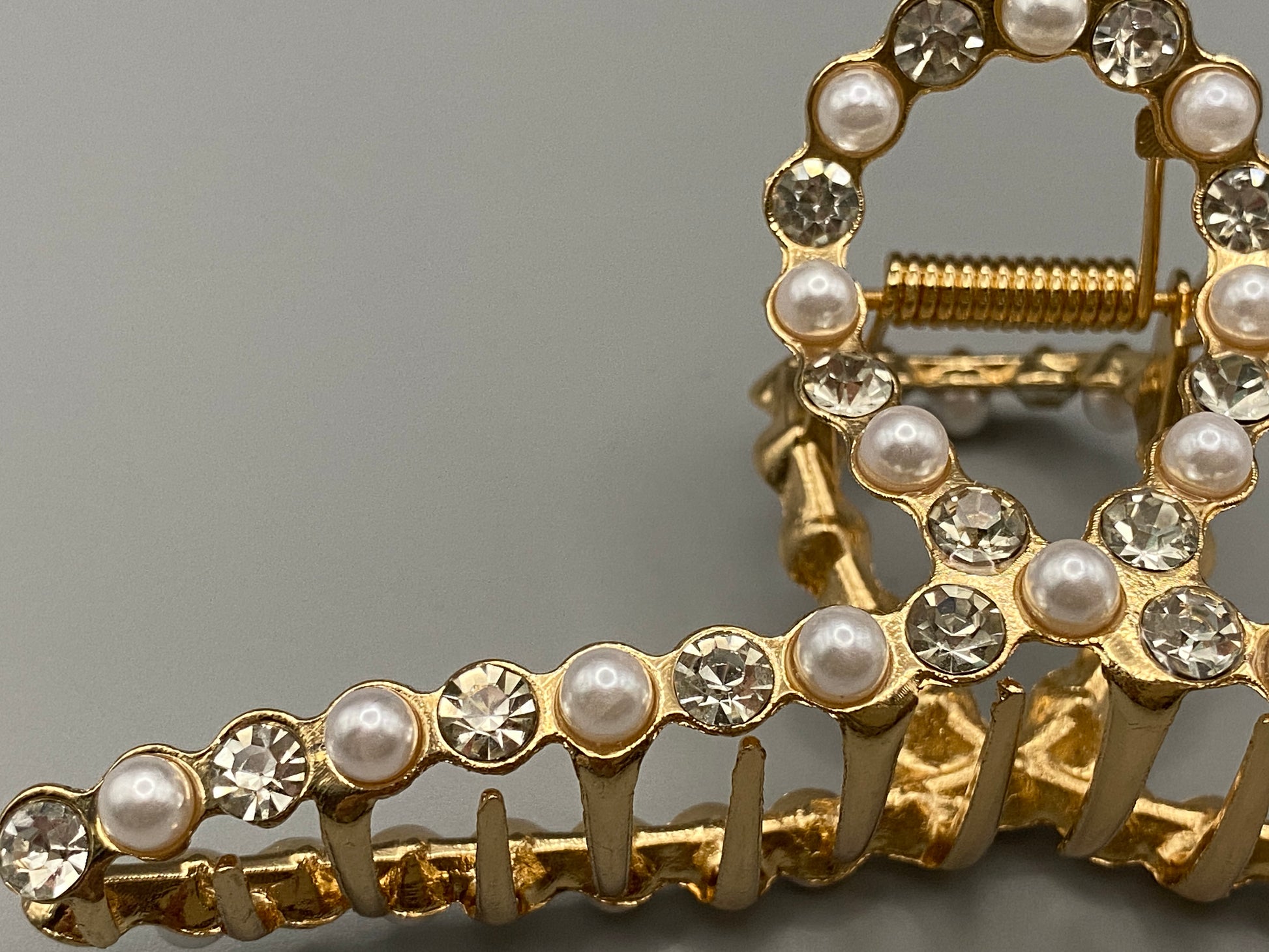 “The Luxe Claw Clip Pearl and Gem Inlay in Gold, crafted from high-quality, durable metal. Measures 11 cm, featuring a luxurious gold finish with beautiful pearl and gem accents. Perfect for securing various hair types and styles, suitable for both everyday wear and special occasions.”