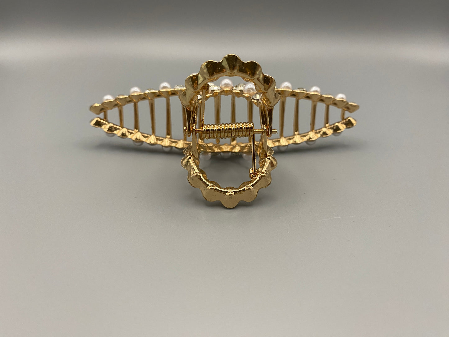 “The Luxe Claw Clip Pearl and Gem Inlay in Gold, crafted from high-quality, durable metal. Measures 11 cm, featuring a luxurious gold finish with beautiful pearl and gem accents. Perfect for securing various hair types and styles, suitable for both everyday wear and special occasions.”