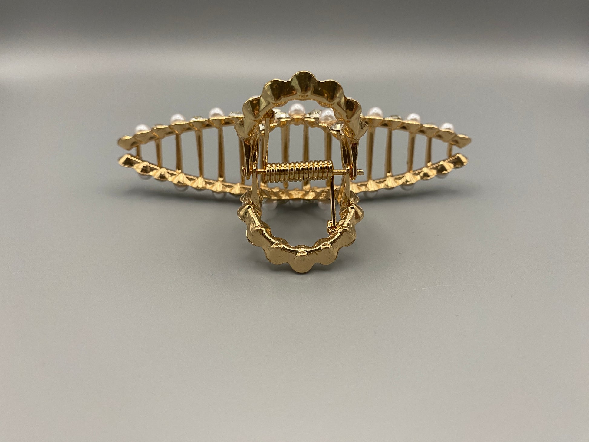 “The Luxe Claw Clip Pearl and Gem Inlay in Gold, crafted from high-quality, durable metal. Measures 11 cm, featuring a luxurious gold finish with beautiful pearl and gem accents. Perfect for securing various hair types and styles, suitable for both everyday wear and special occasions.”