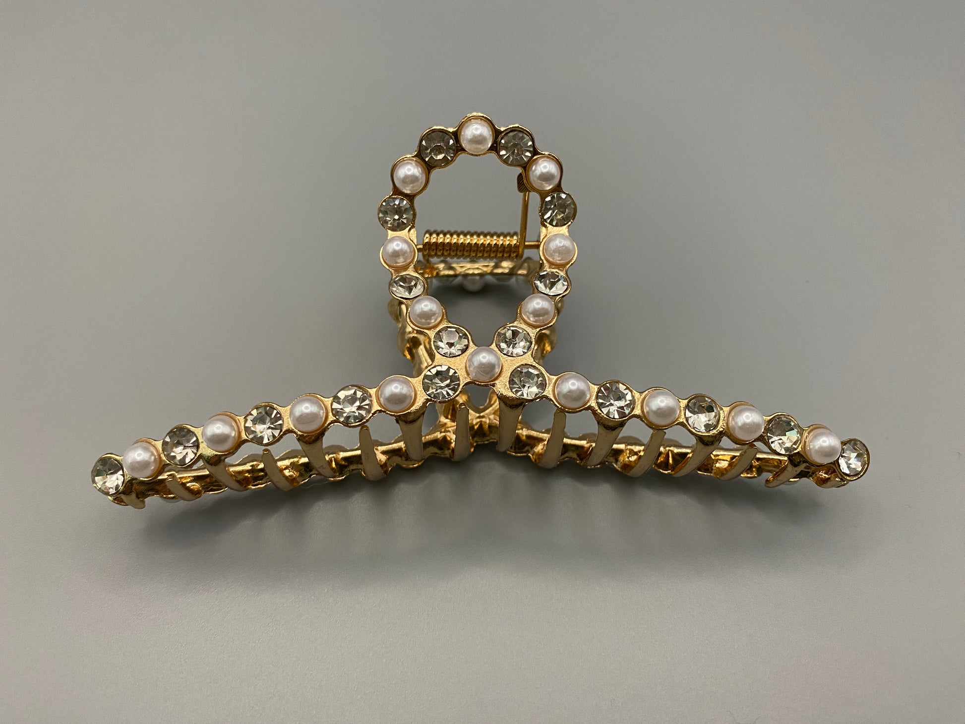 “The Luxe Claw Clip Pearl and Gem Inlay in Gold, crafted from high-quality, durable metal. Measures 11 cm, featuring a luxurious gold finish with beautiful pearl and gem accents. Perfect for securing various hair types and styles, suitable for both everyday wear and special occasions.”