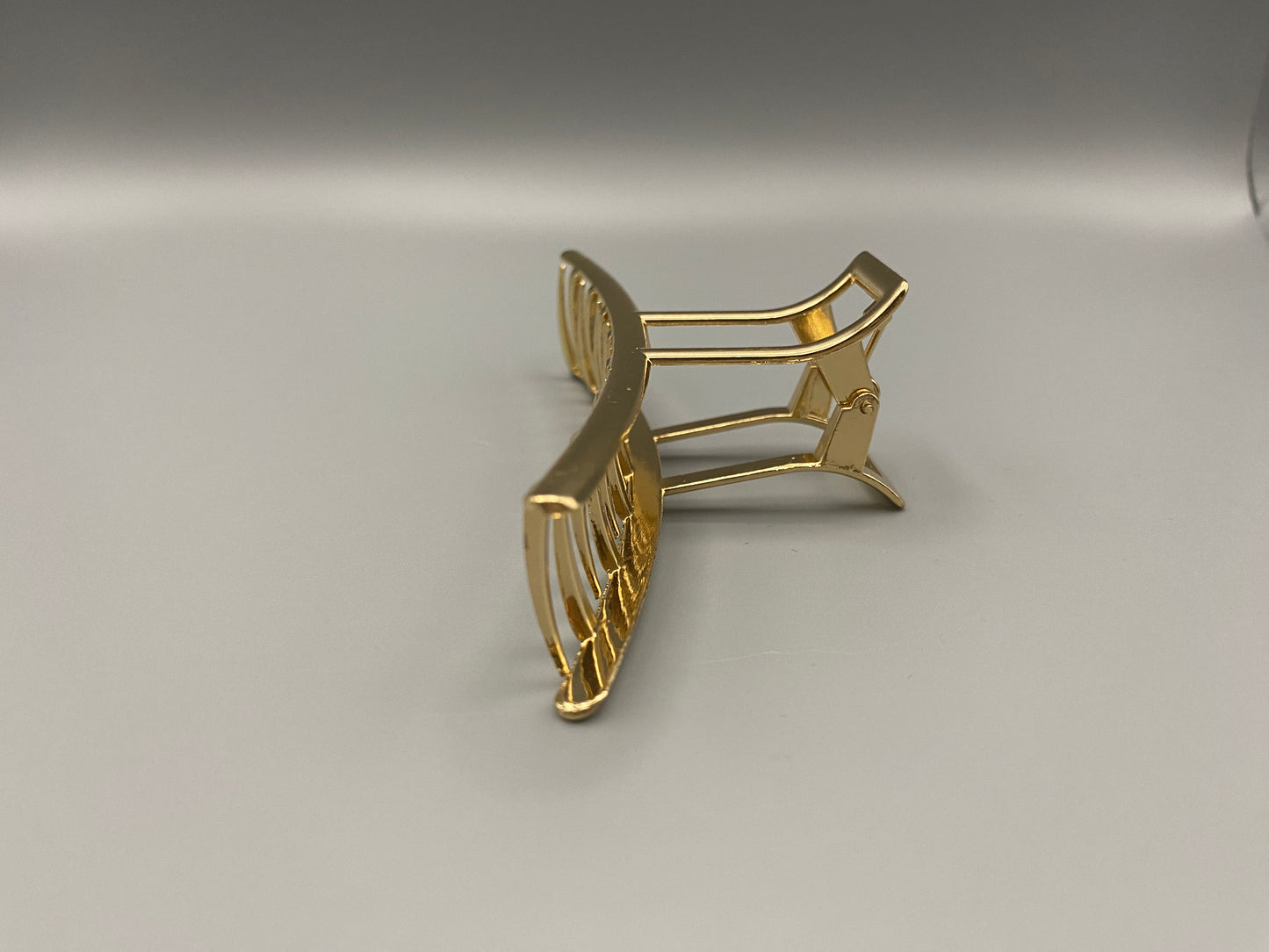 “The Luxe Claw Clip Metal Bow in Gold, crafted from high-quality, durable metal. Measures 11 cm, featuring a luxurious gold finish and unique link design. Perfect for securing various hair types and styles, suitable for both everyday wear and special occasions.”