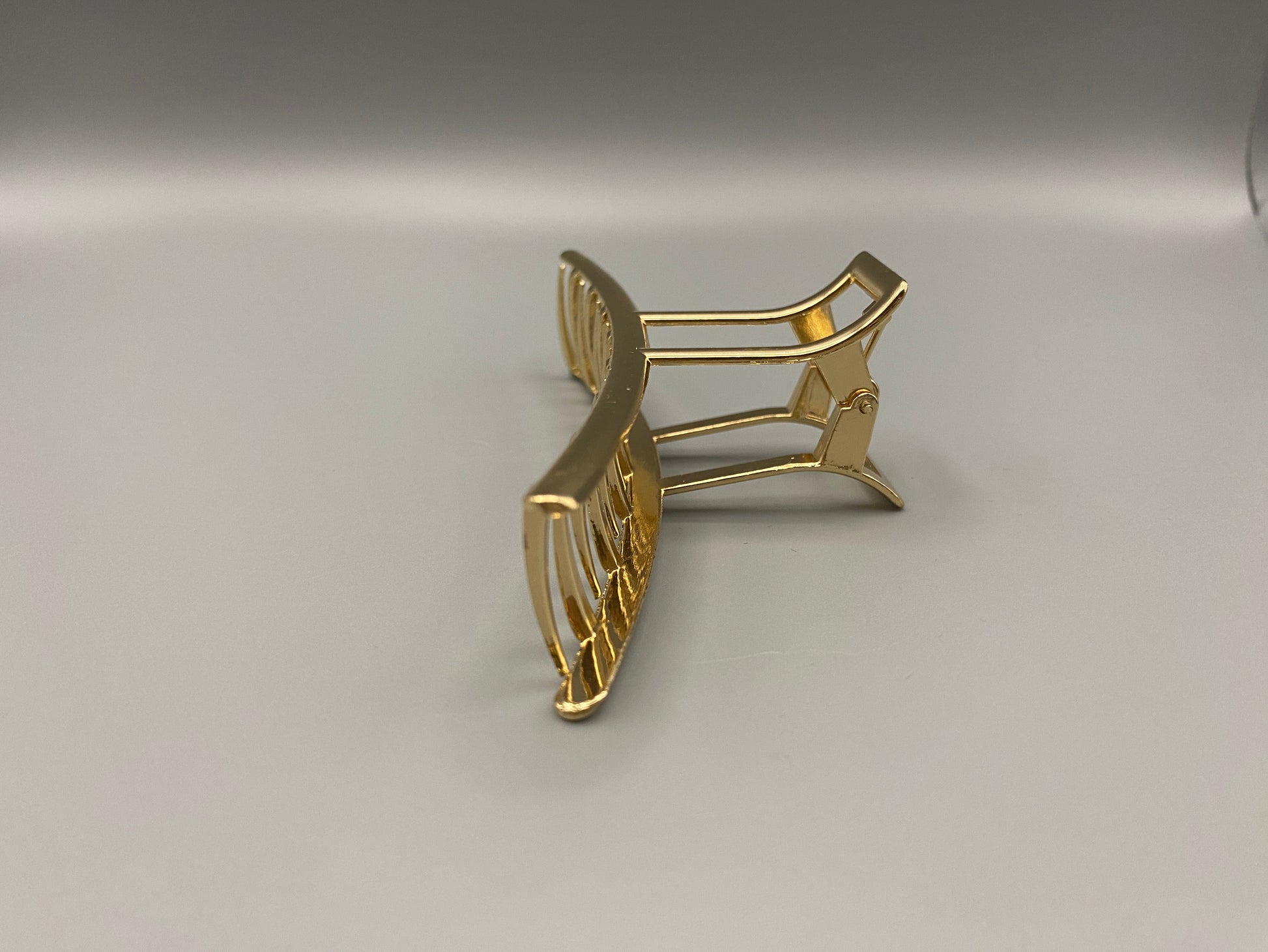 “The Luxe Claw Clip Metal Bow in Gold, crafted from high-quality, durable metal. Measures 11 cm, featuring a luxurious gold finish and unique link design. Perfect for securing various hair types and styles, suitable for both everyday wear and special occasions.”