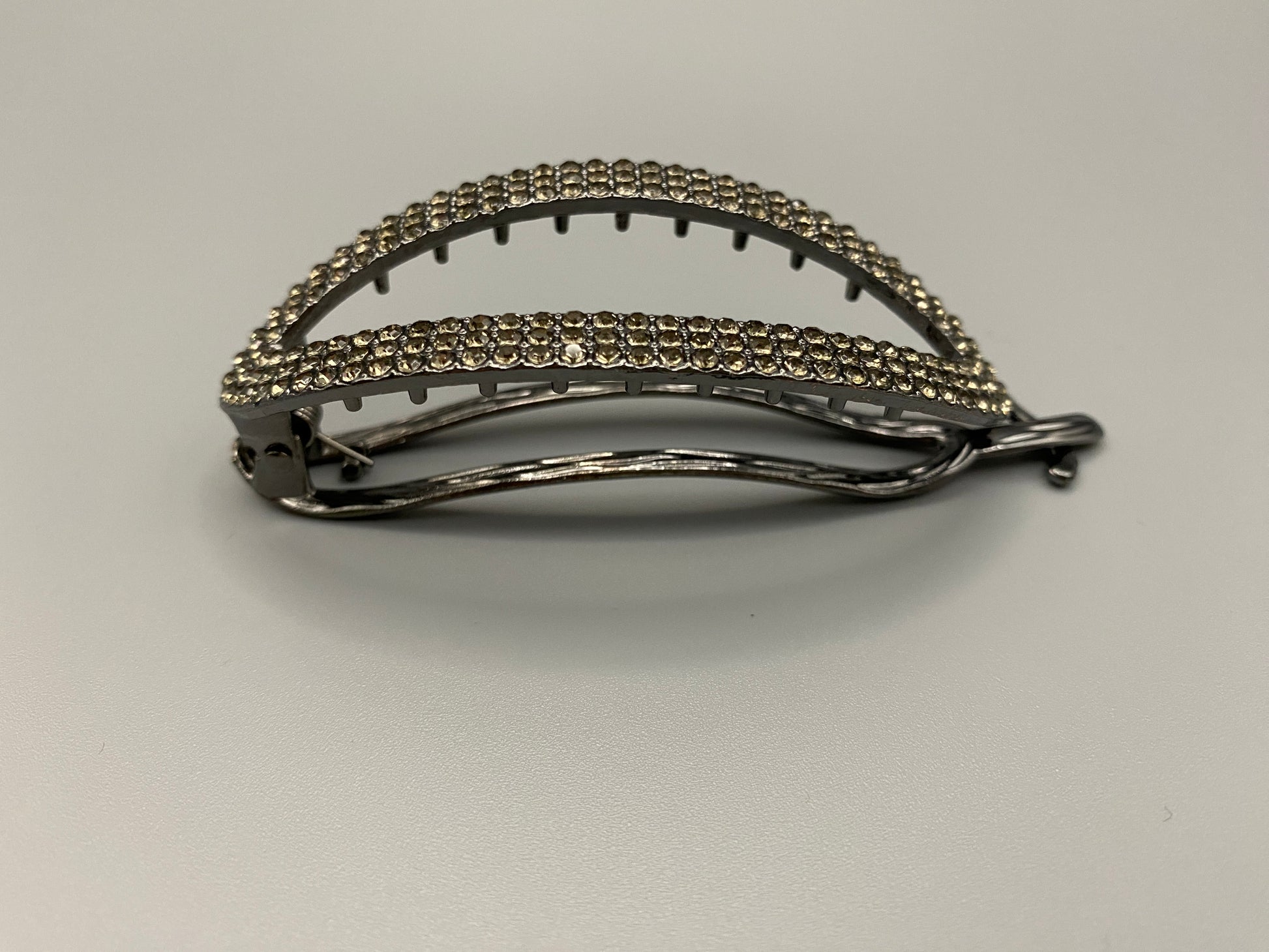 “The Missy Hair Clip, crafted from high-quality metal with sparkling zircon inlaid stones. Features a delicate curved design, measures 9 cm in length, and is perfect for securing various hair types and styles. Durable and luxurious, ideal for effortless beauty.”