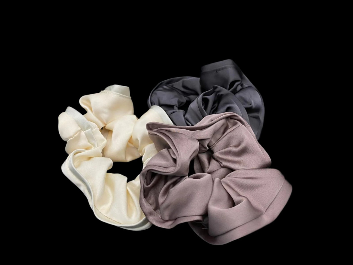 “The Rebecca Flower Scrunchie in Grey, featuring a flower-shaped design made from durable and soft satin material. Measures 11 cm, perfect for creating voluminous and eye-catching hairdos. Chic and versatile, ideal for adding a touch of vintage elegance to any outfit.”