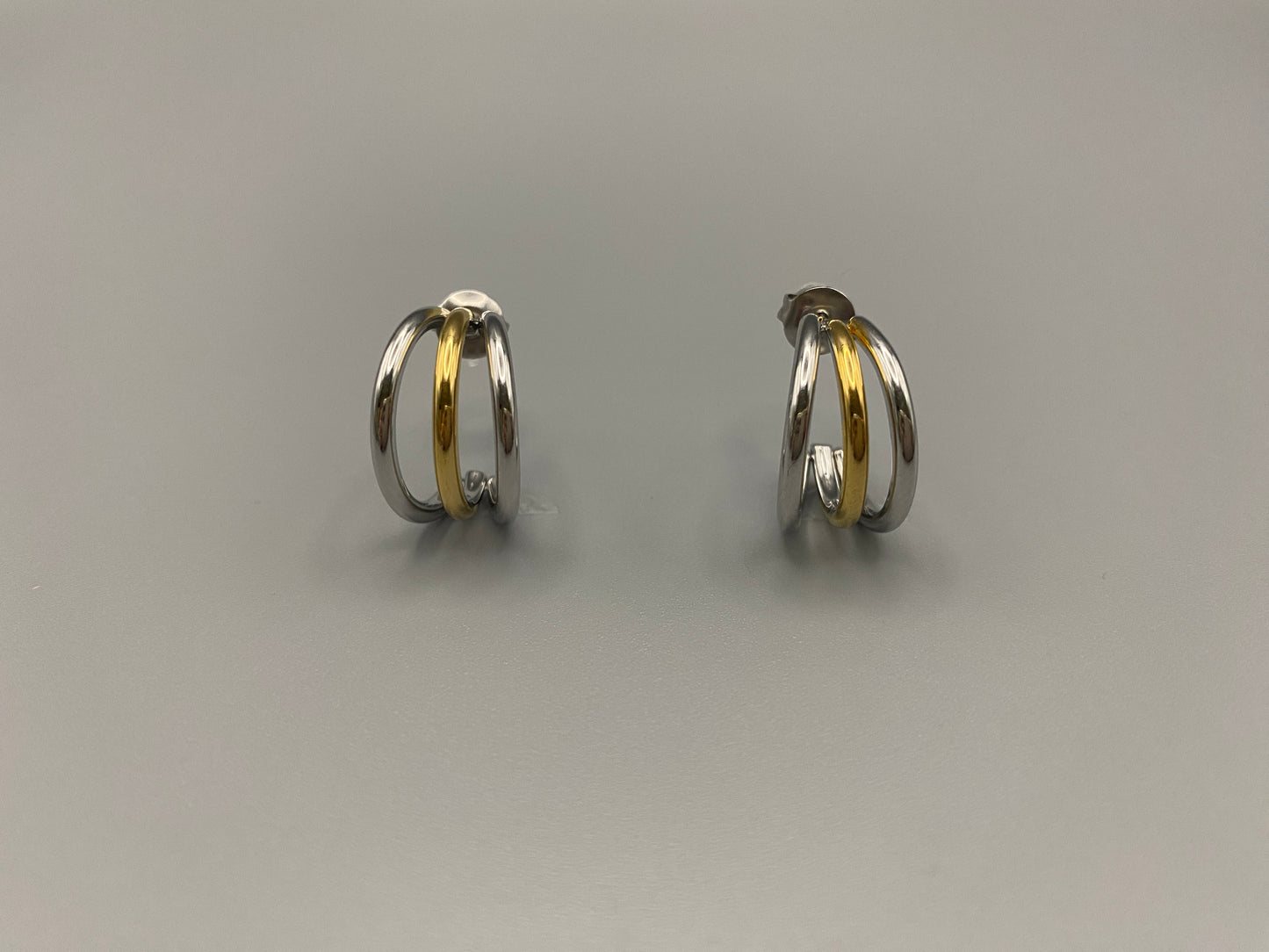 “Trinity 3 Band C Shaped Earrings Gold and Silver: A perfect blend of elegance and modern design, featuring sleek gold and silver bands, a luxurious gold-plated band, and durable stainless steel construction. Unique three-band C shape, ideal for any occasion.”