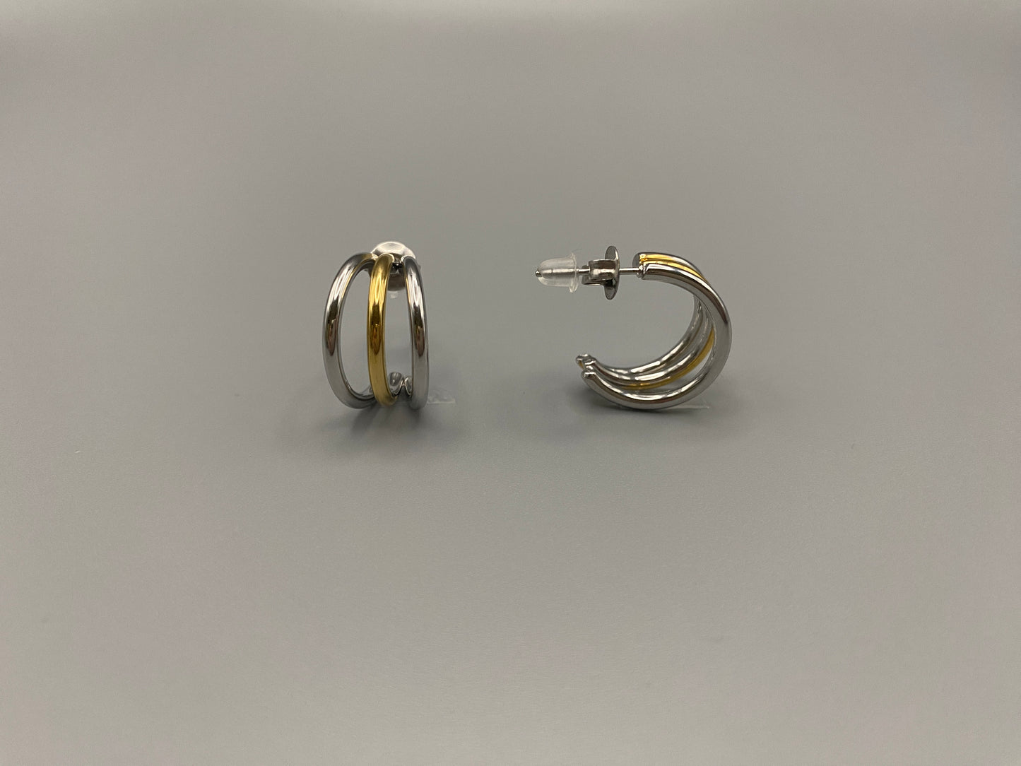 “Trinity 3 Band C Shaped Earrings Gold and Silver: A perfect blend of elegance and modern design, featuring sleek gold and silver bands, a luxurious gold-plated band, and durable stainless steel construction. Unique three-band C shape, ideal for any occasion.”