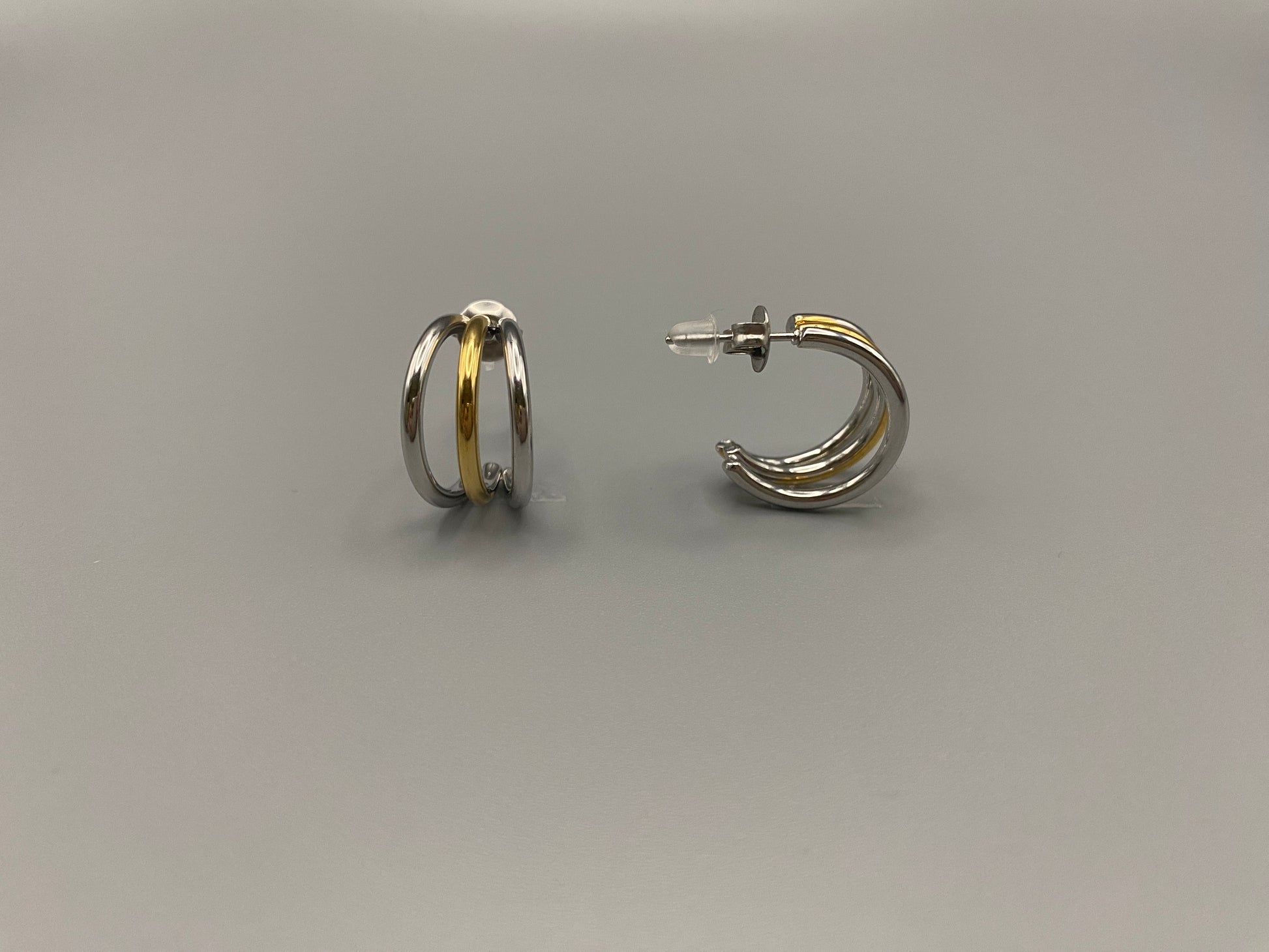 “Trinity 3 Band C Shaped Earrings Gold and Silver: A perfect blend of elegance and modern design, featuring sleek gold and silver bands, a luxurious gold-plated band, and durable stainless steel construction. Unique three-band C shape, ideal for any occasion.”