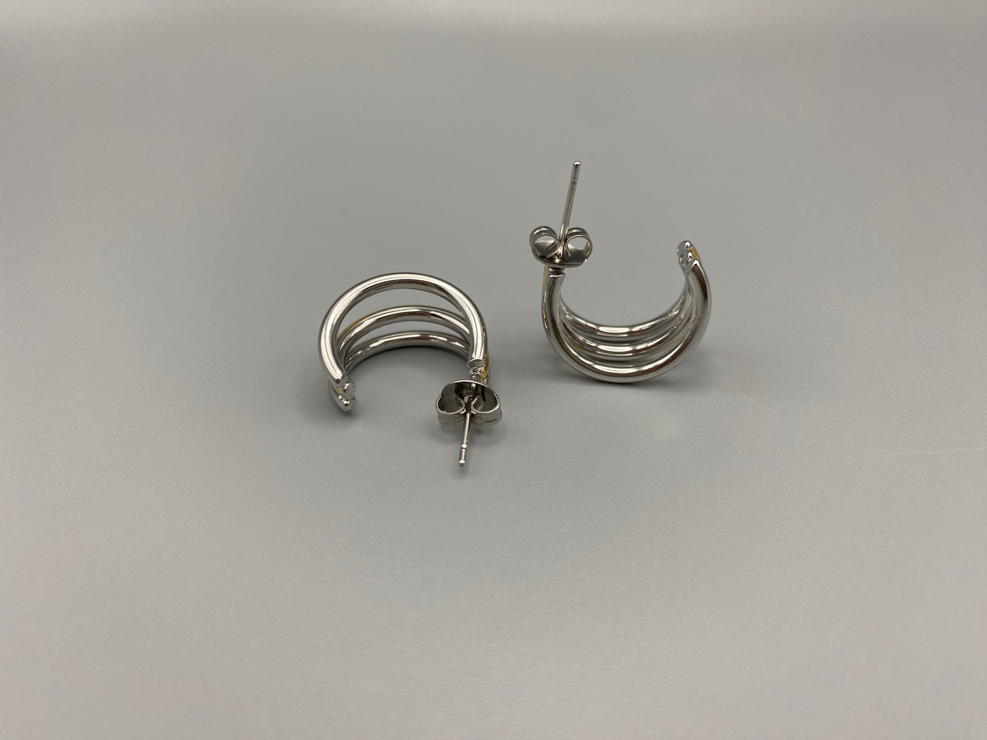 “Trinity 3 Band C Shaped Earrings Gold and Silver: A perfect blend of elegance and modern design, featuring sleek gold and silver bands, a luxurious gold-plated band, and durable stainless steel construction. Unique three-band C shape, ideal for any occasion.”