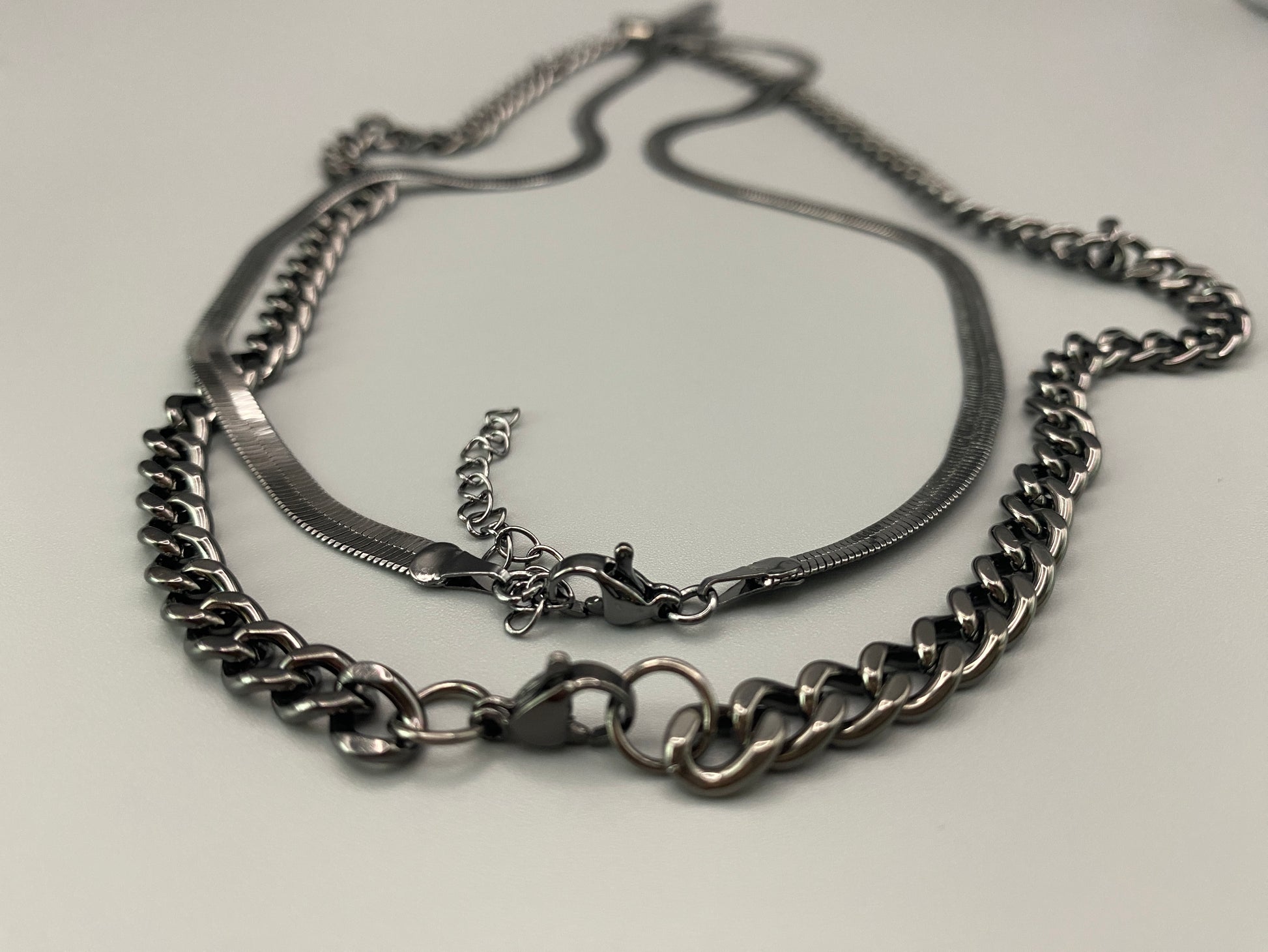 “Men’s Twin Chain Cross Necklace: A stylish black stainless steel necklace featuring a twin chain design with a silver-plated cross pendant. Perfect for teens and adults, this fine jewelry piece is unisex and measures 45 cm with a 5 cm extender.”