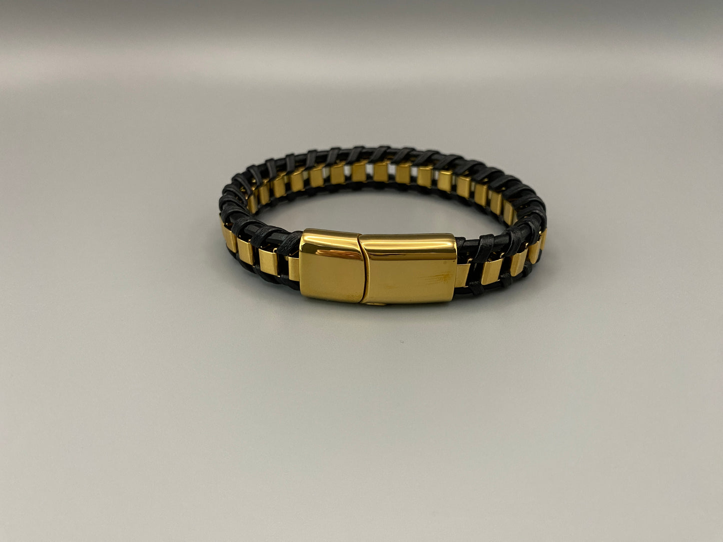 “Urban Edge Wrist Wear Men’s Bracelet in black, crafted from premium stainless steel with a casual and sporty design. Measures 19 cm in length, available in Black Zinc Plated, 18K Gold Plated, and Silver Plated finishes. Features inlay technology for added detail and craftsmanship.”