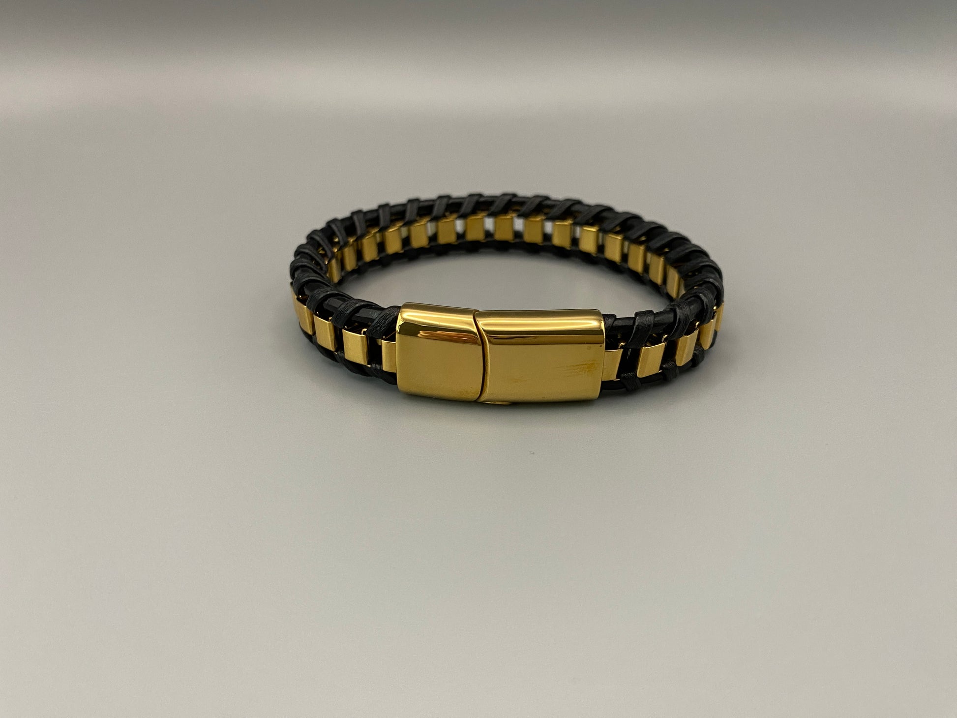 “Urban Edge Wrist Wear Men’s Bracelet in black, crafted from premium stainless steel with a casual and sporty design. Measures 19 cm in length, available in Black Zinc Plated, 18K Gold Plated, and Silver Plated finishes. Features inlay technology for added detail and craftsmanship.”