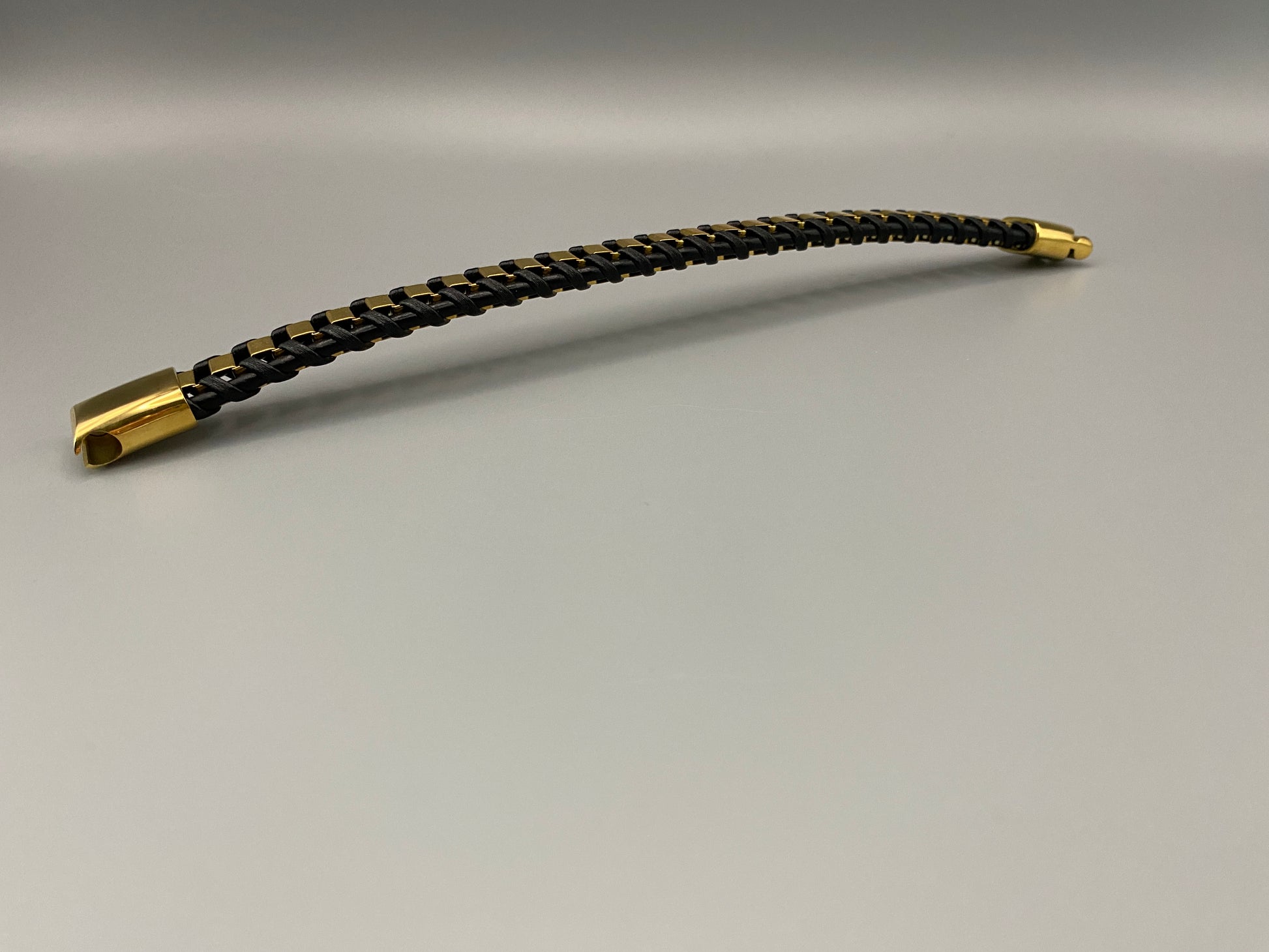 “Urban Edge Wrist Wear Men’s Bracelet in black, crafted from premium stainless steel with a casual and sporty design. Measures 19 cm in length, available in Black Zinc Plated, 18K Gold Plated, and Silver Plated finishes. Features inlay technology for added detail and craftsmanship.”