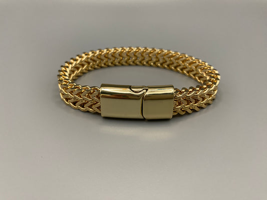 “A men’s bracelet with a chain and link design, made from shiny titanium steel. The bracelet features a geometric pattern and a smart magnet button clasp. It is available in silver, gold, and black colors, and measures 19-23 cm in length.”